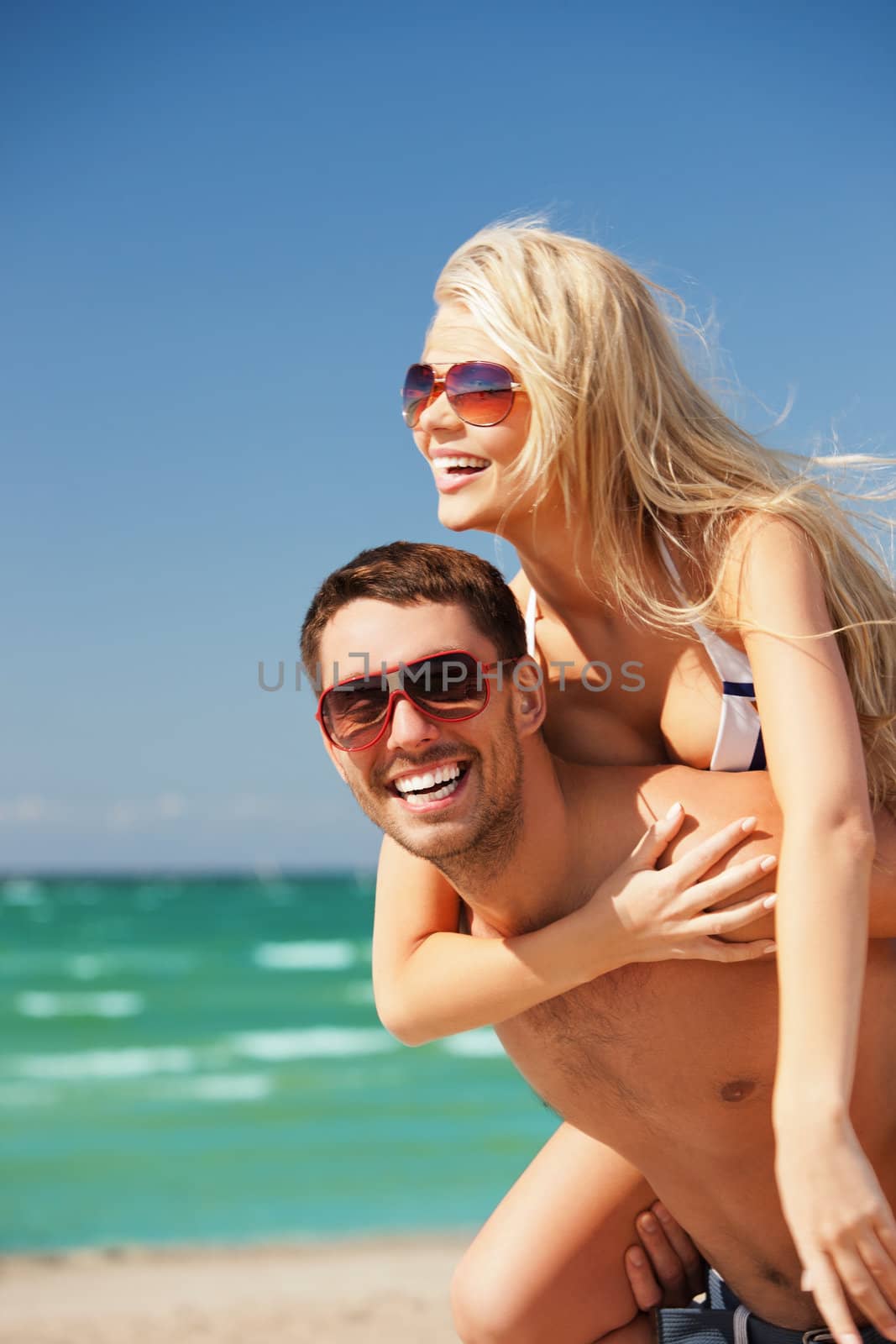 happy couple in sunglasses on the beach by dolgachov