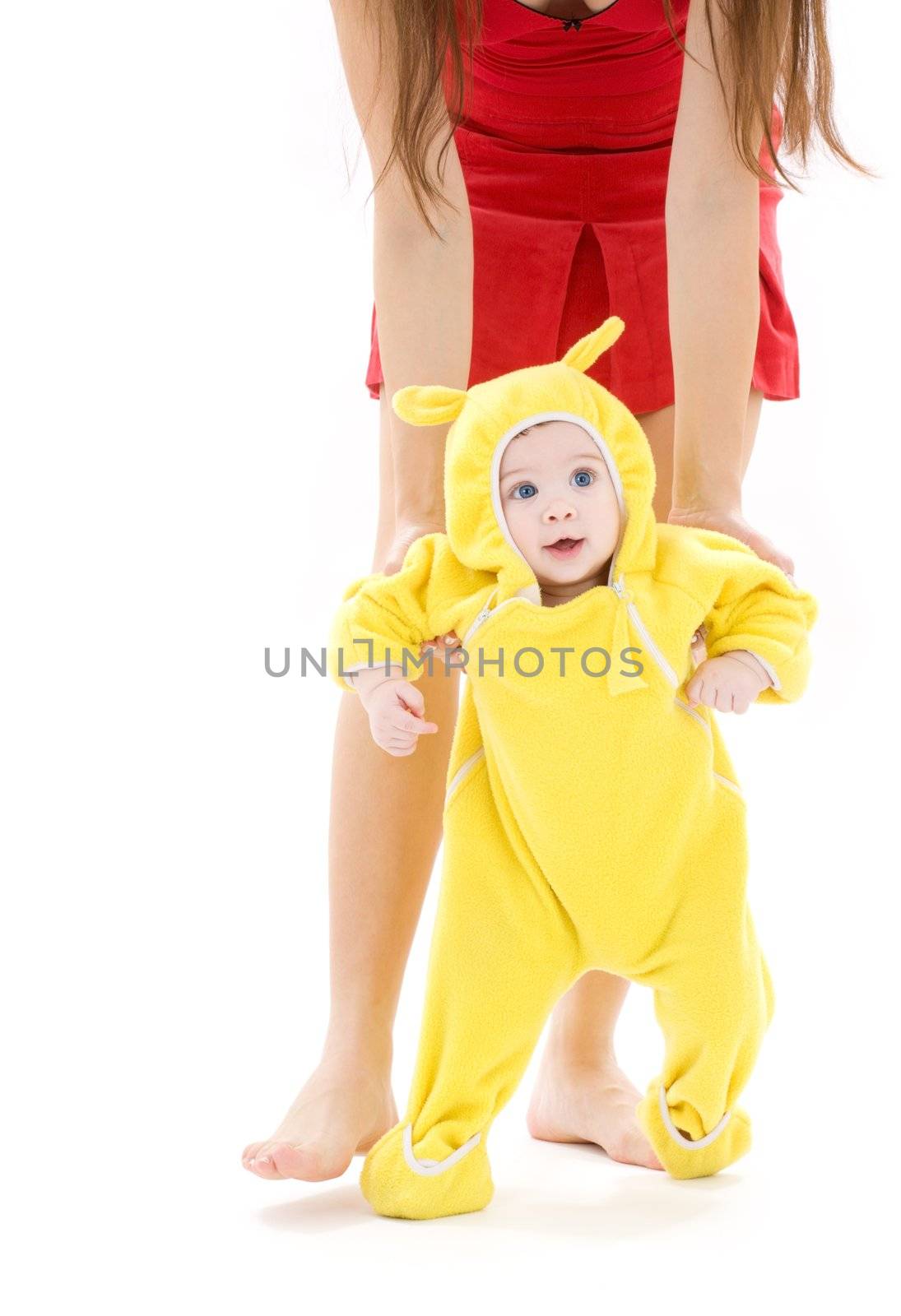 baby in yellow suit making first steps