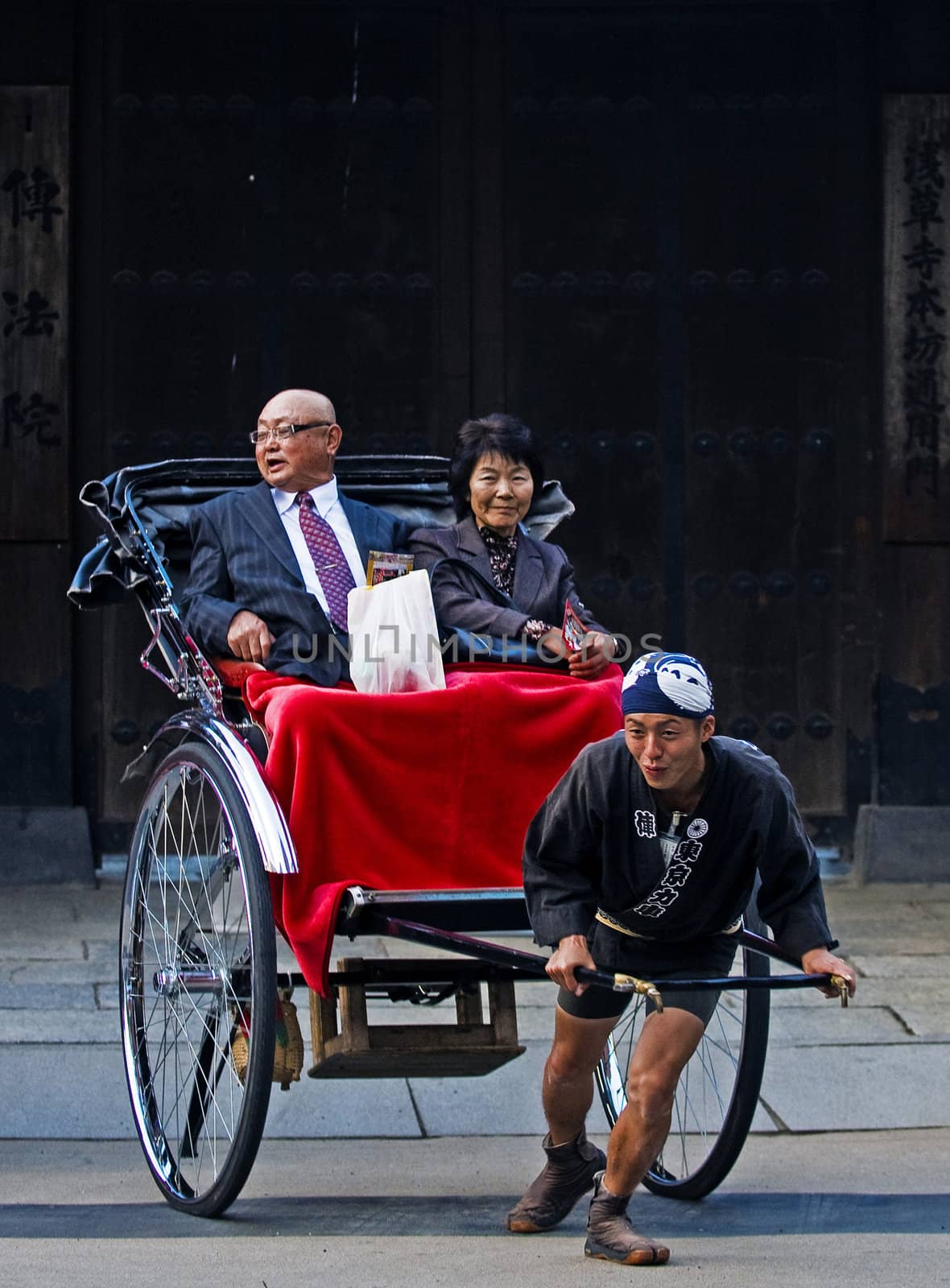 TOKYO - OCT 29 : Japanese couple on a trditional rickshaw being pulled on October 29 2009 in Tokyo , Japan