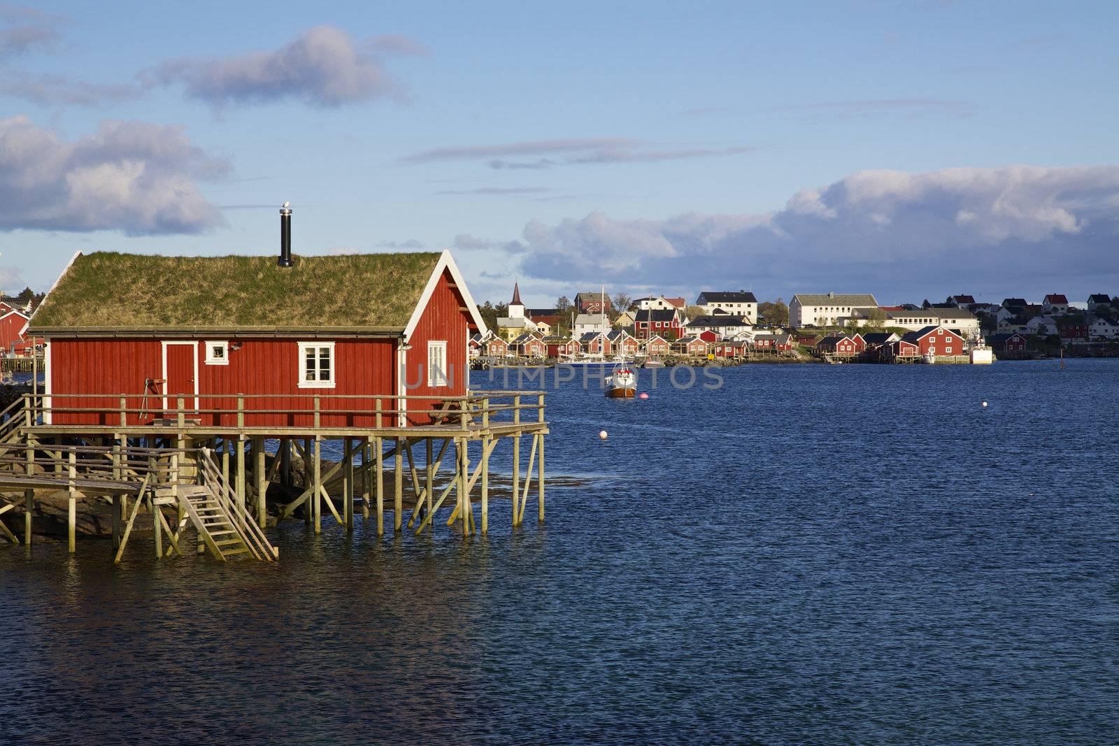 Typical red rorbu hut with sod roof in town of Reine on Lofoten islands in Norway