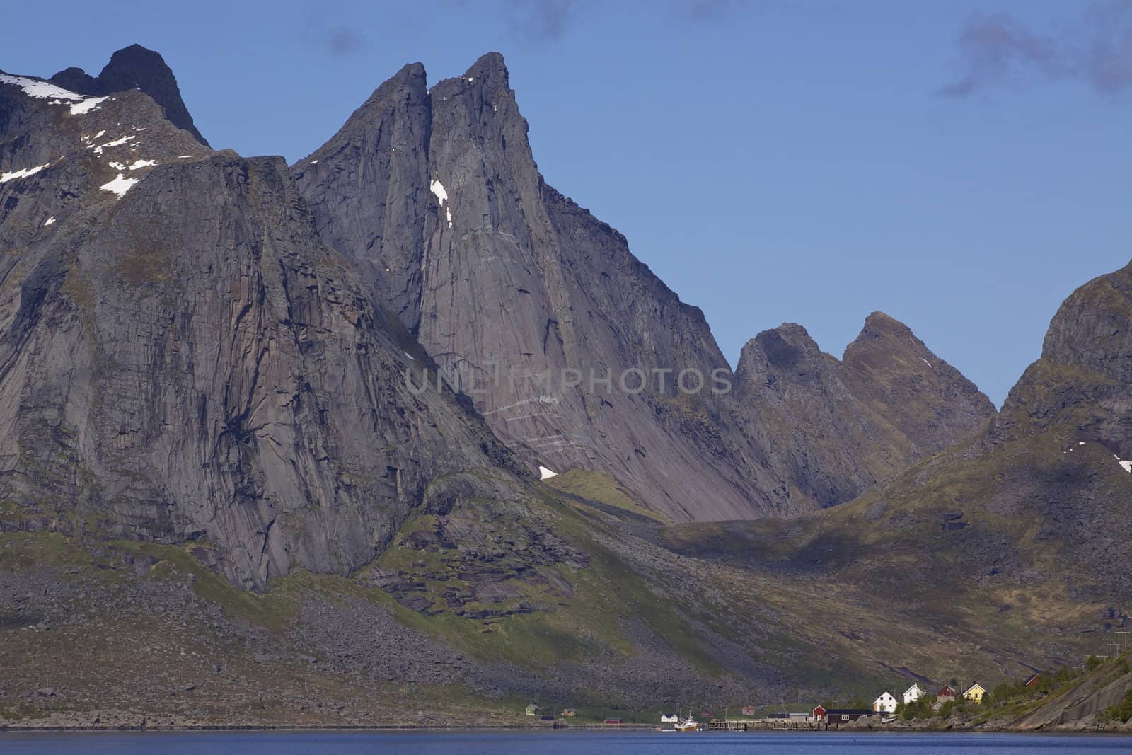 Scenic fjord Reinefjorden on Lofoten islands in Norway, with high rocky mountain peaks towering above the sea