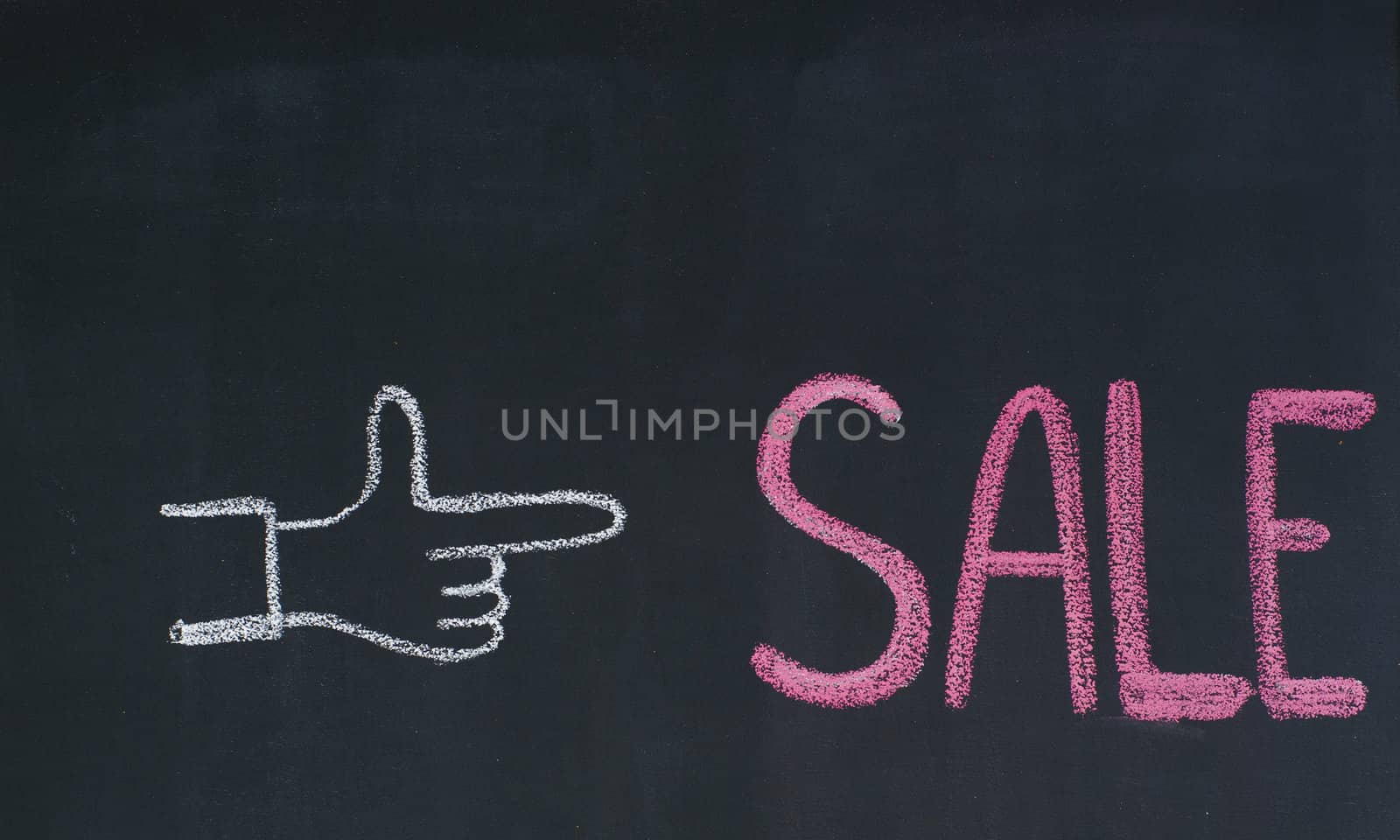 Hand pointing to the word Sale, written on a blackboard
