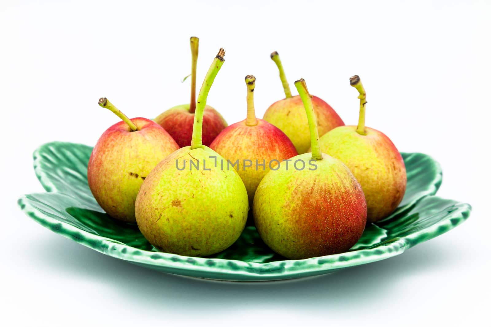 Lots of little ripe pears on white background