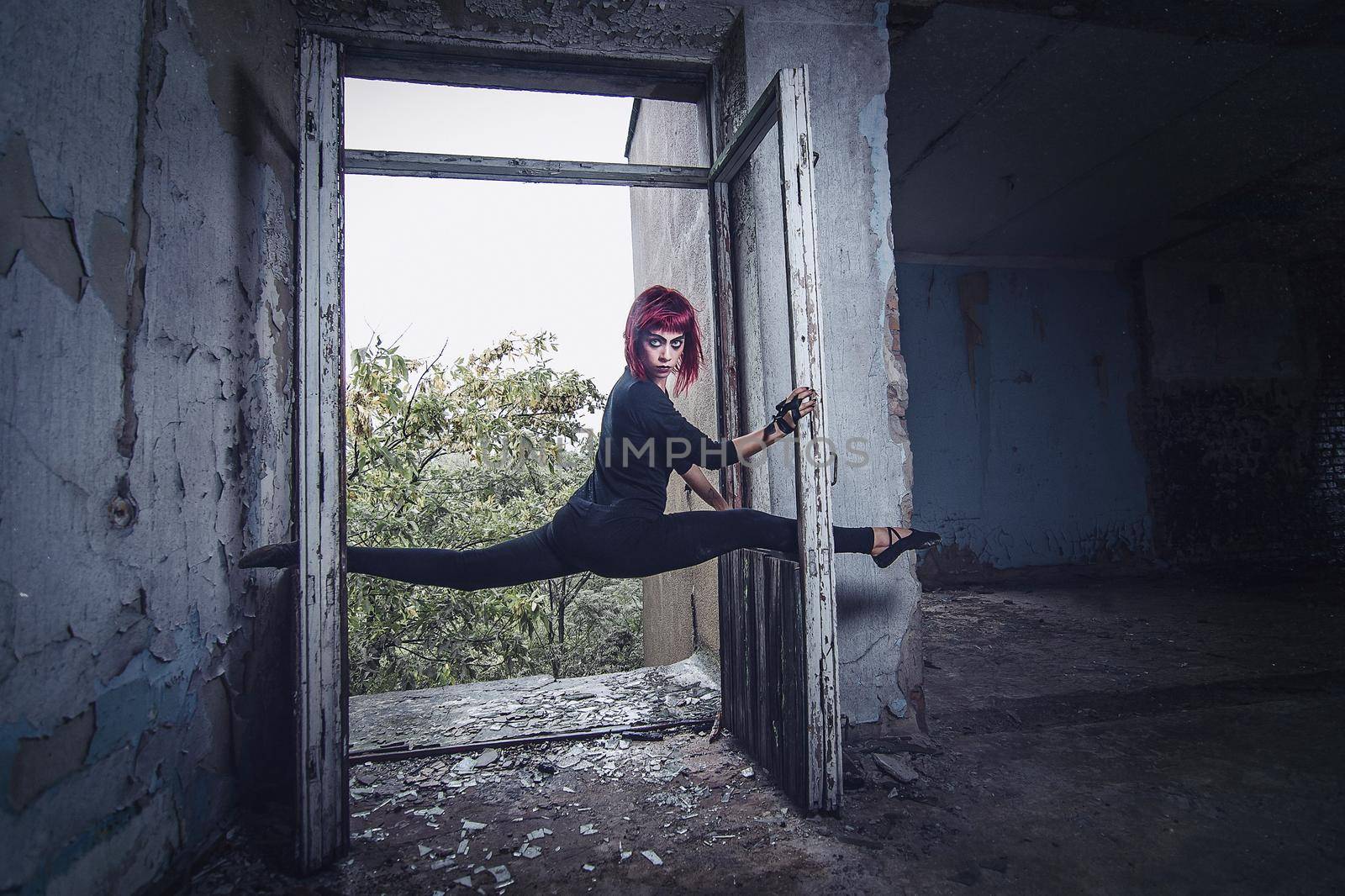 girl model in black with pink hair in an abandoned building