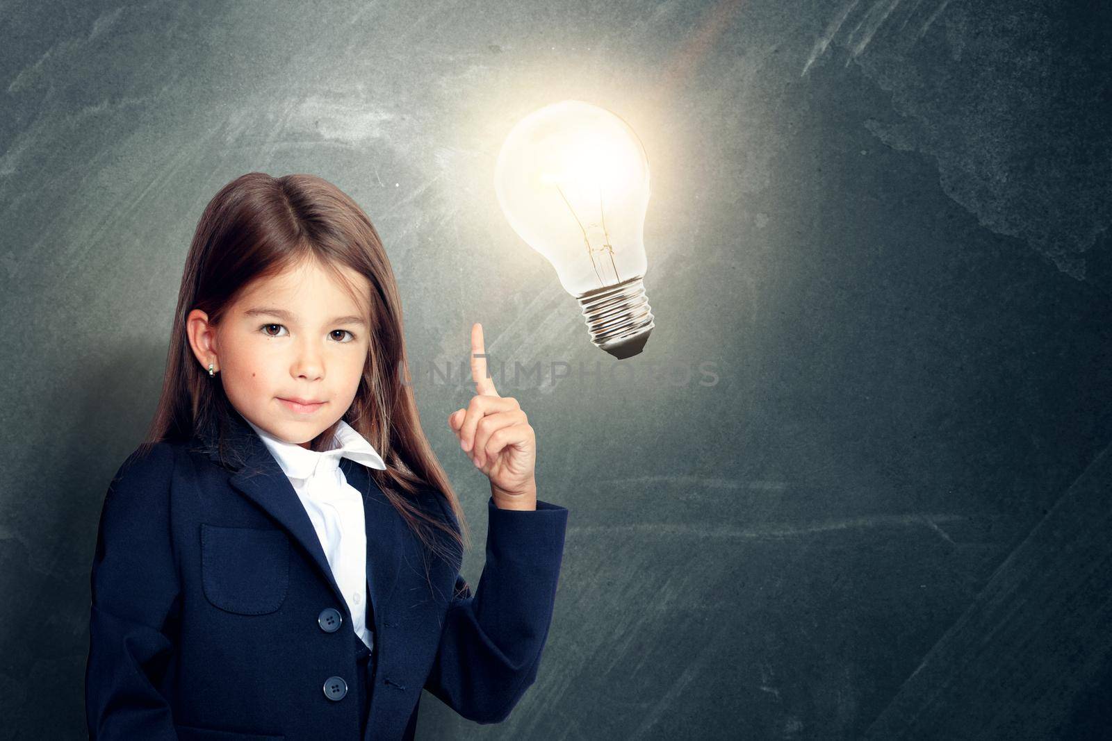 Young cute girl at chalkboard with light bulb over head by Taut