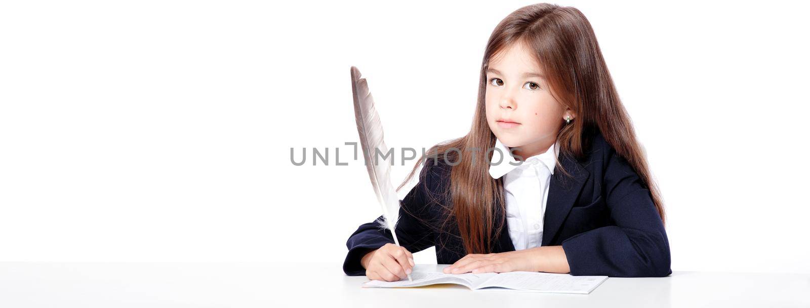 Happy and cute teen school girl writes in a book or notebook by Taut