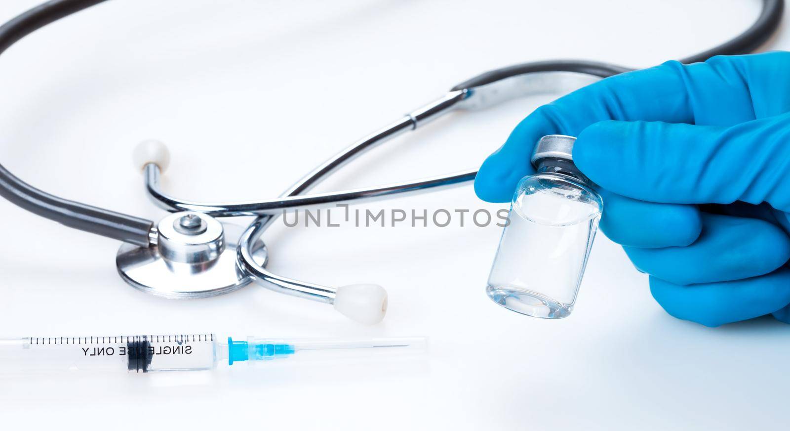 Hand holding viol with vaccine against corona virus. by Taut