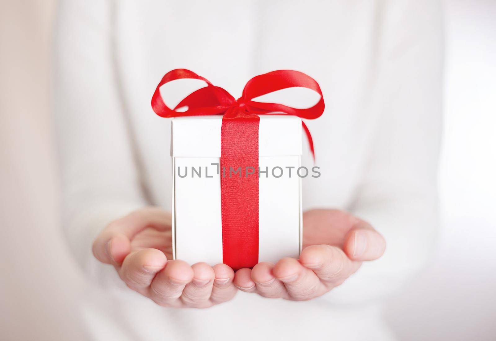 Gift box in wrapping paper with satin ribbon. Merry Christmas holiday concept.