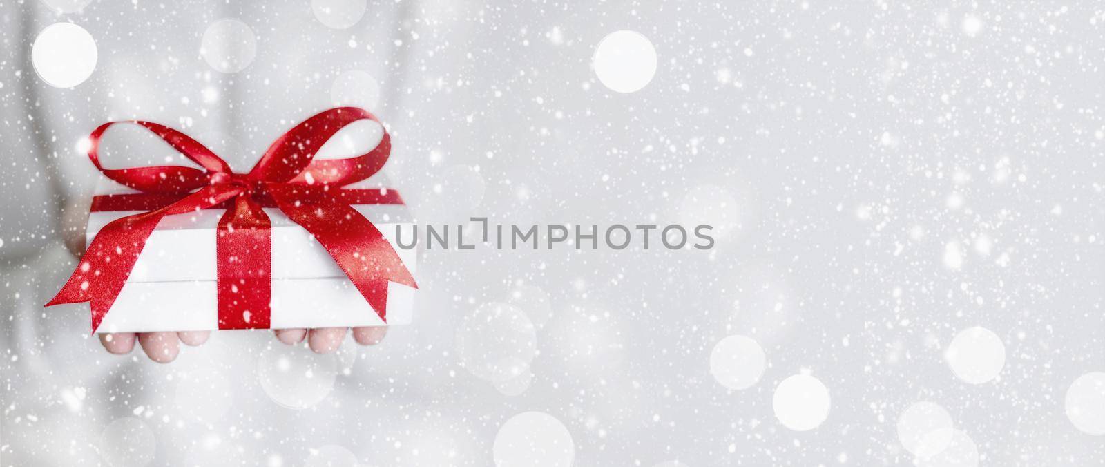 Gift box in wrapping paper with satin ribbon. Merry Christmas holiday concept.
