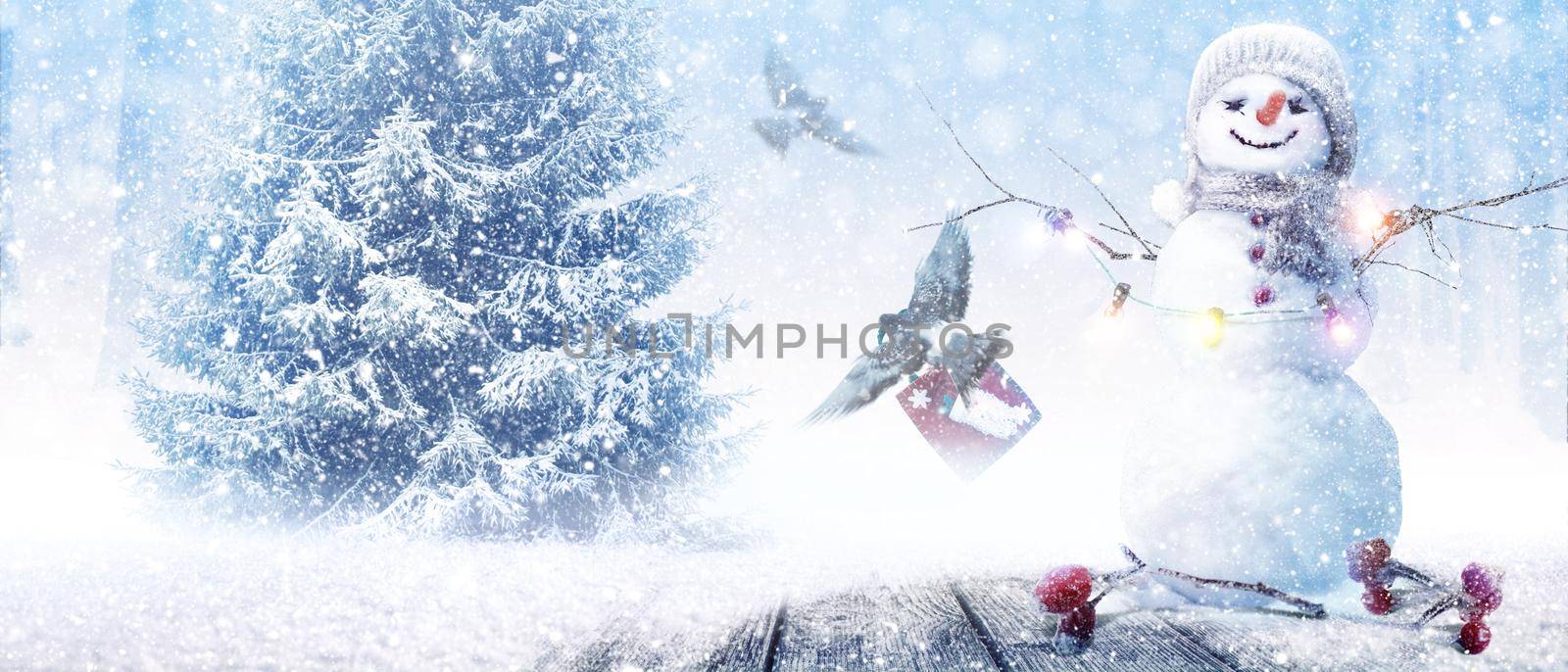 Happy snowman standing in winter christmas landscape.