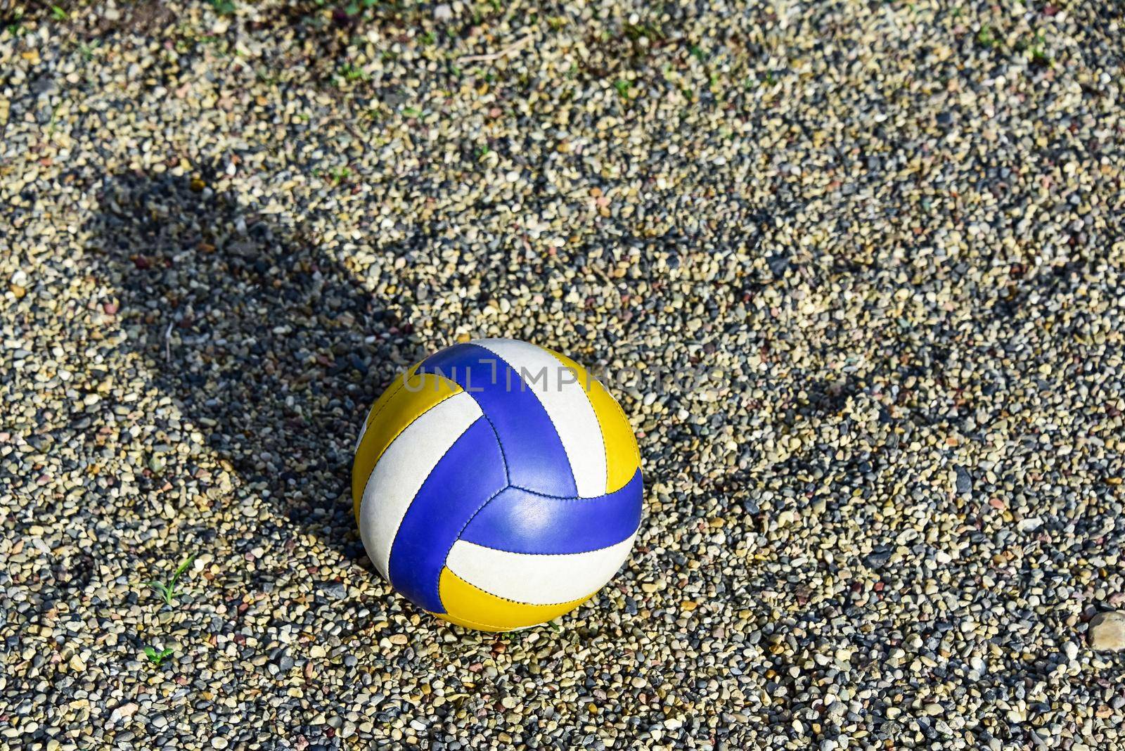Close up of colored volleyball ball on a sea pebble beach. Summer beach games.