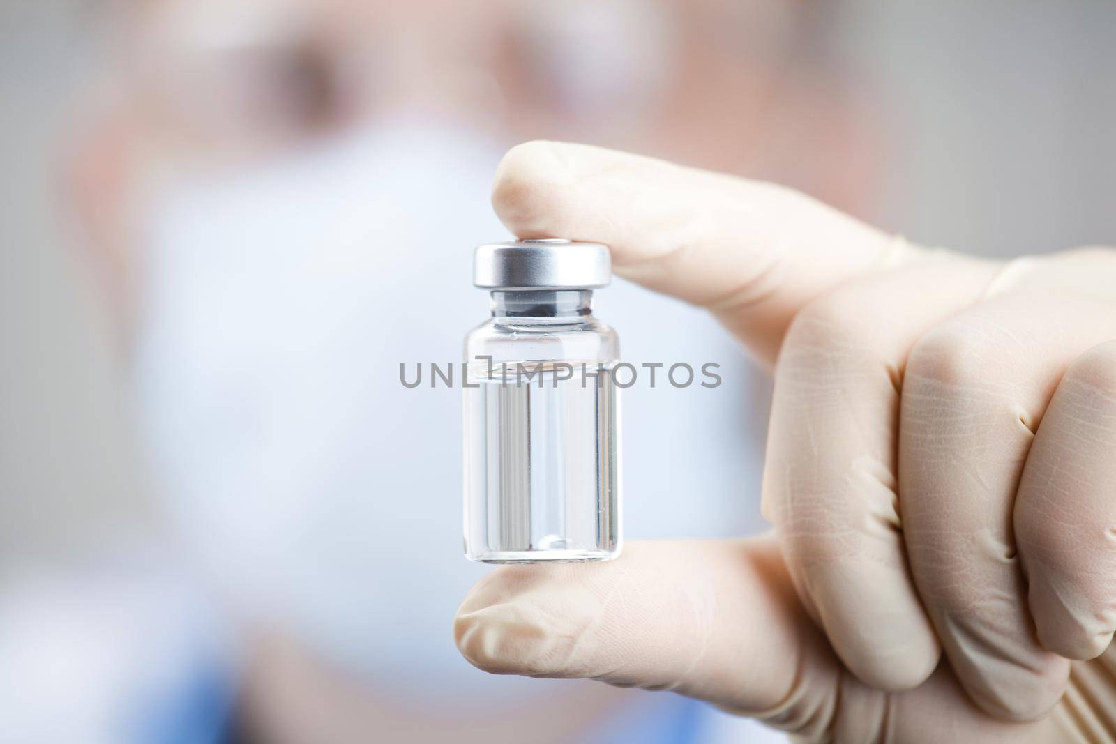 Doctor holding a viol with vaccine against corona virus. by Taut