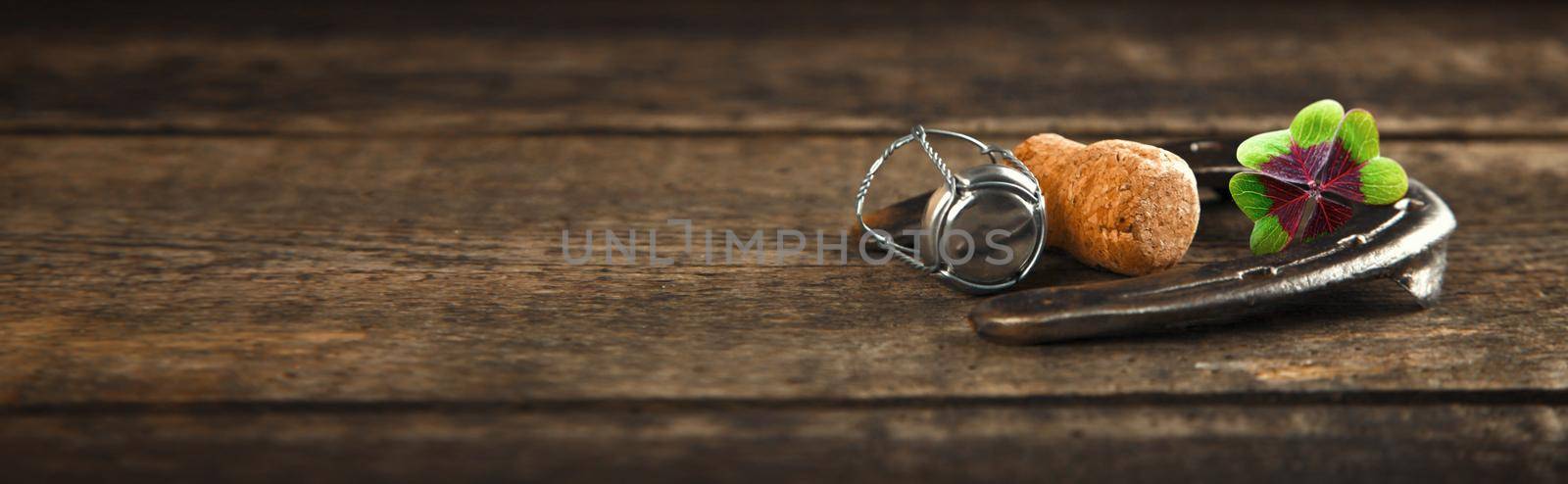 Horseshoe with lucky clover on a wooden background by Taut