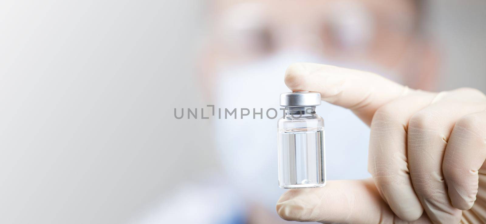 Doctor holding a viol with vaccine against corona virus. by Taut