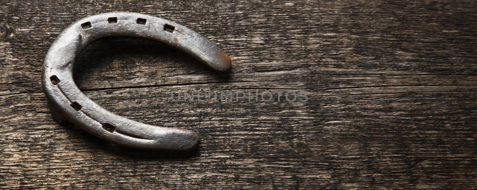 Horseshoe with lucky clover on a wooden background by Taut