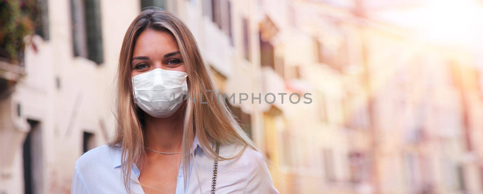 Beautiful tourist woman with corona virus mask at the island of Venice in Italy by Taut