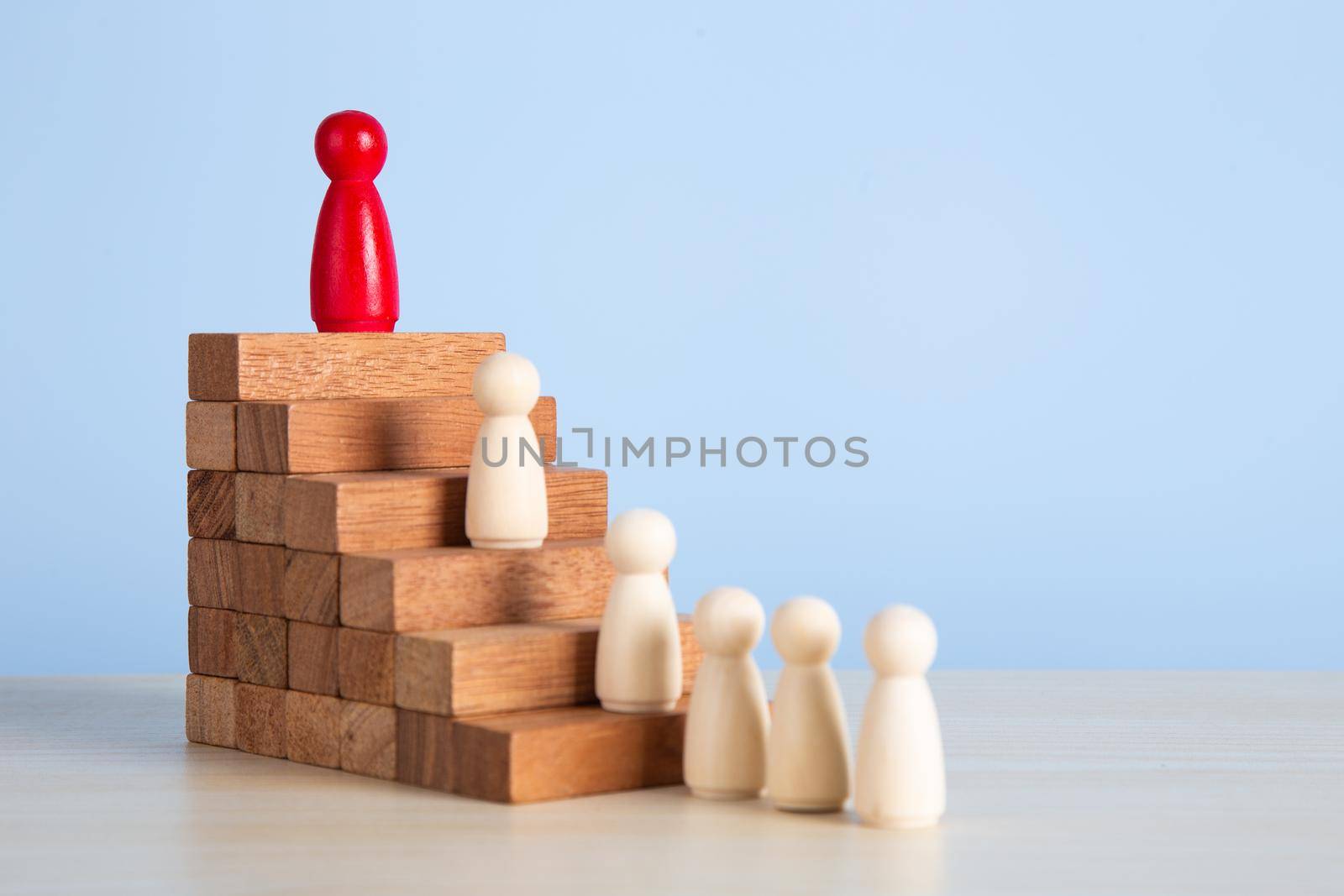 Career growth, development. Leadership, goal achievement. Wooden people figures on top of wooden blocks