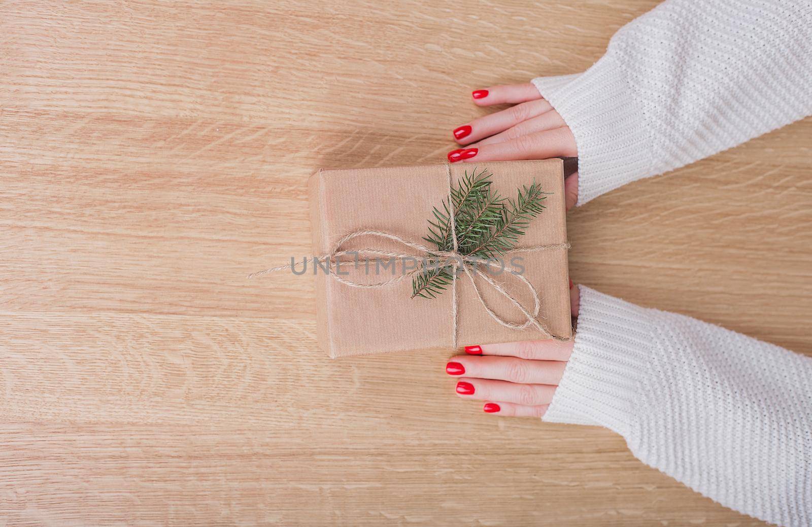 Gift box in wrapping paper with satin ribbon. Merry Christmas holiday concept.