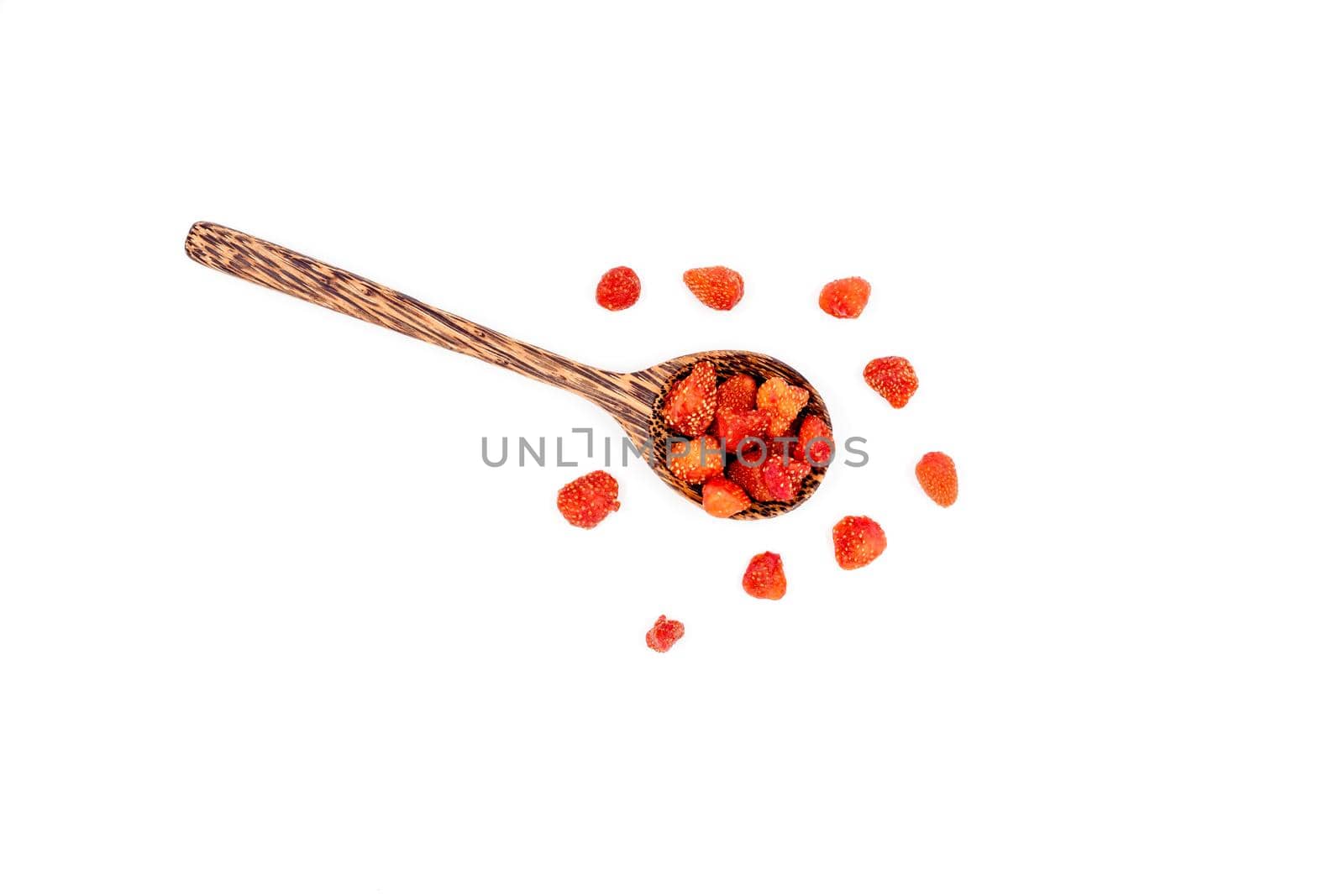Group of dried strawberries in a wooden spoon isolated on white background. by wattanaphob