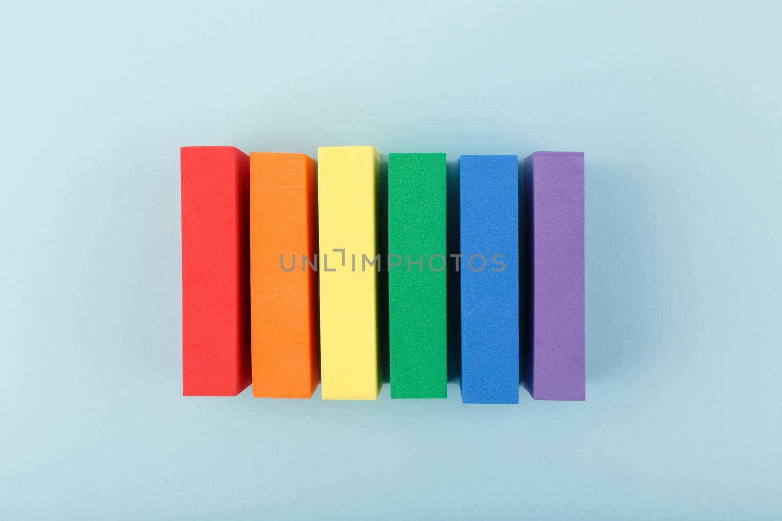 Creative composition with lgbt rainbow flag made of rectangular multicolored tablets on pastel blue light background. Concept of Pride Month, equal rights, LGBT community, respect and tolerance.