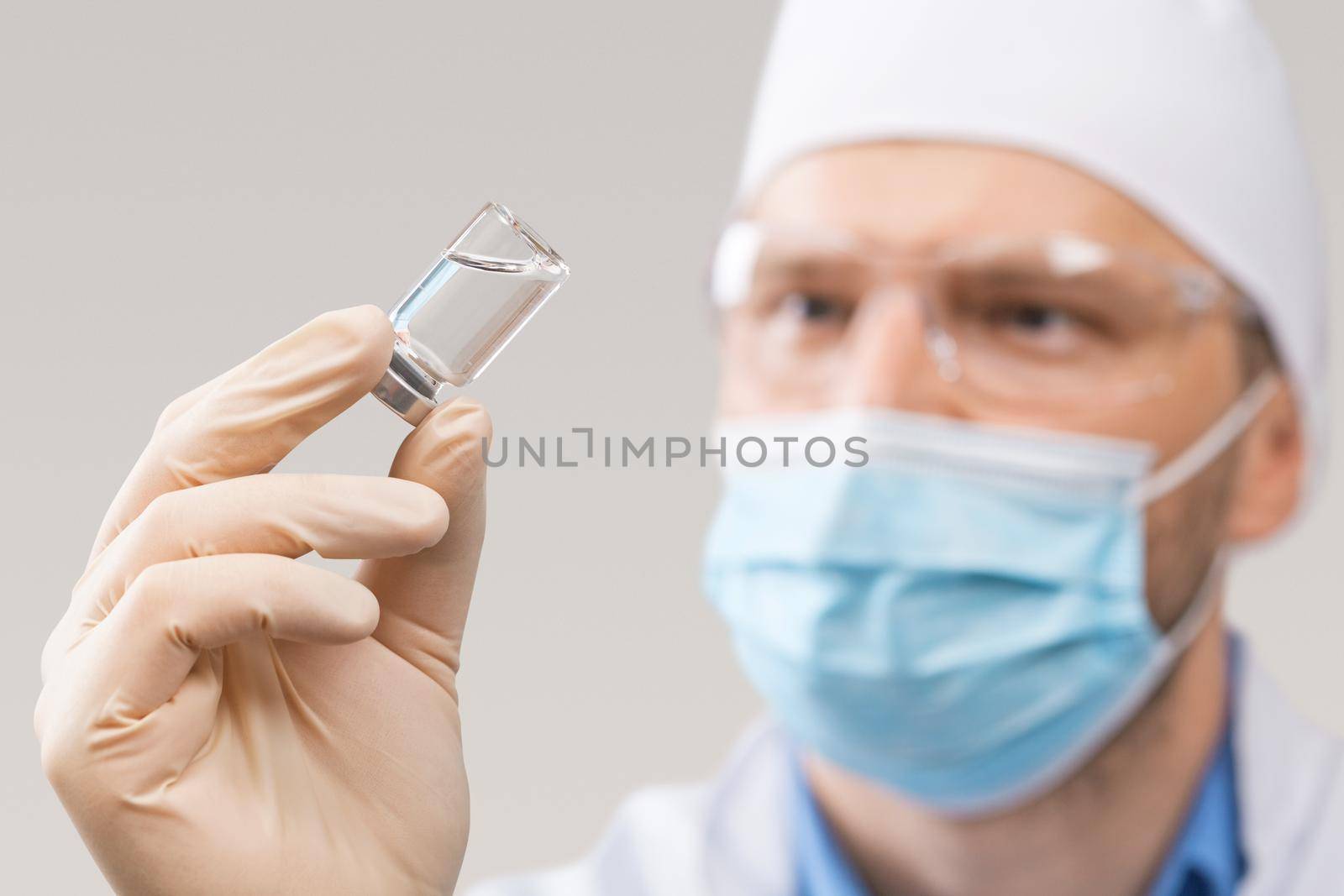 Doctor holding a viol with vaccine against corona virus. by Taut