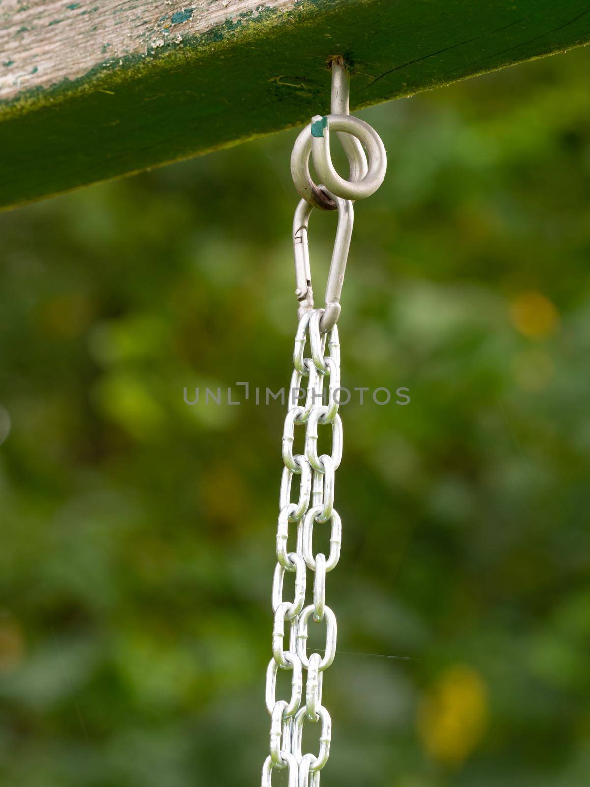 Rope ring knot hanging on wooden beam, trees in blurry background