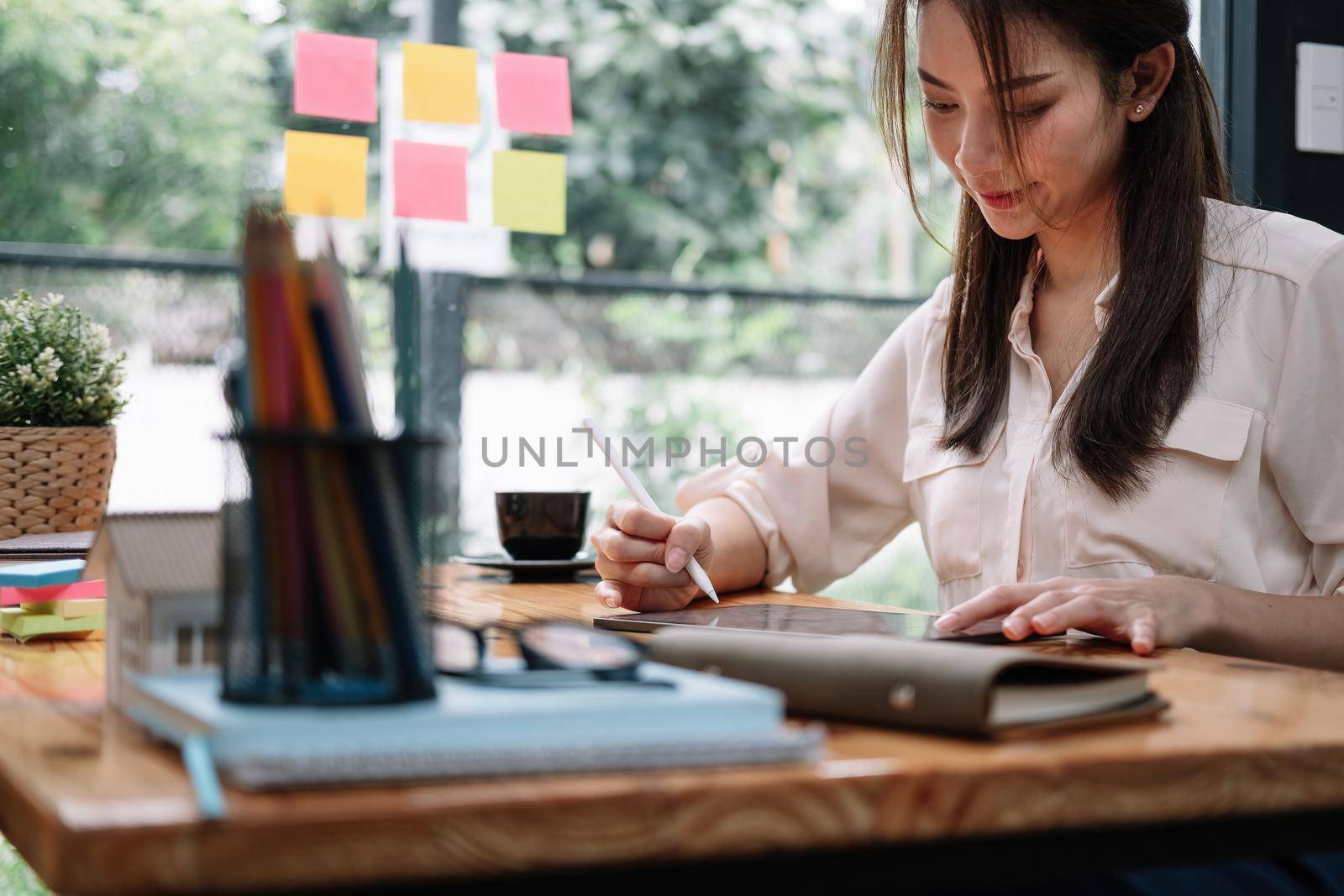 Close up asian woman using computer tablet with stylus at her office. business working concept.