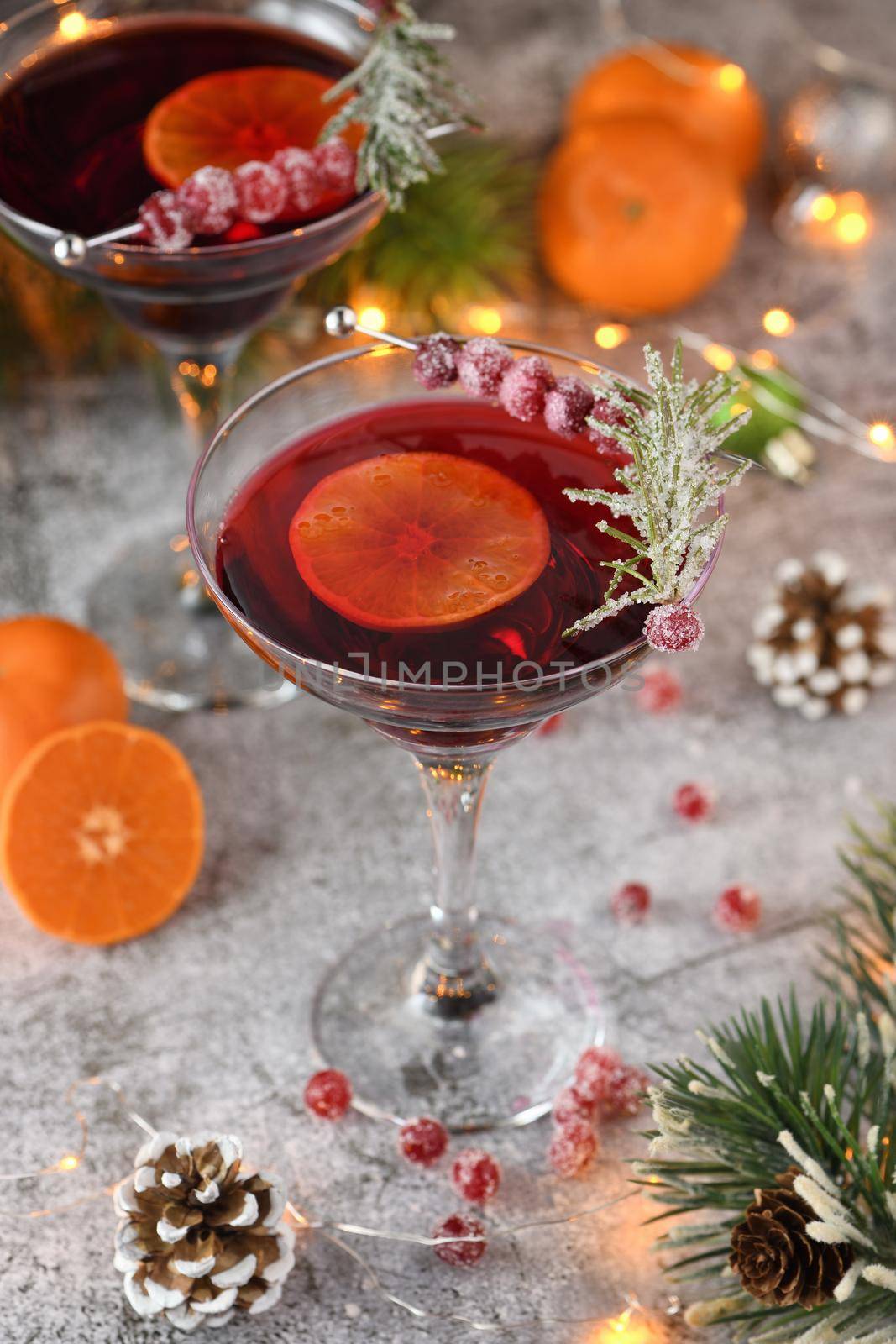 Goblet with cranberry Margarita with candied cranberries, rosemary and tangerine. Perfect cocktail for a Christmas party