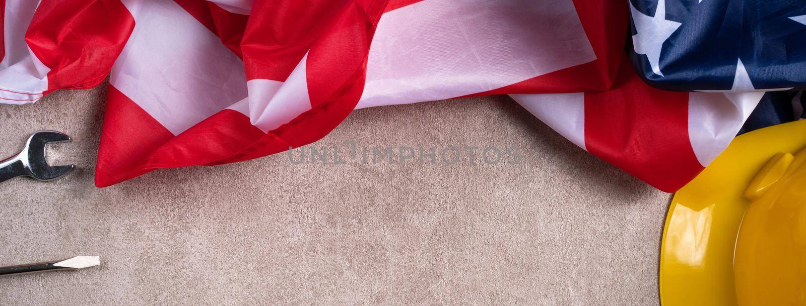 Top view design concept of American Labor Day with working tools on gray table background.