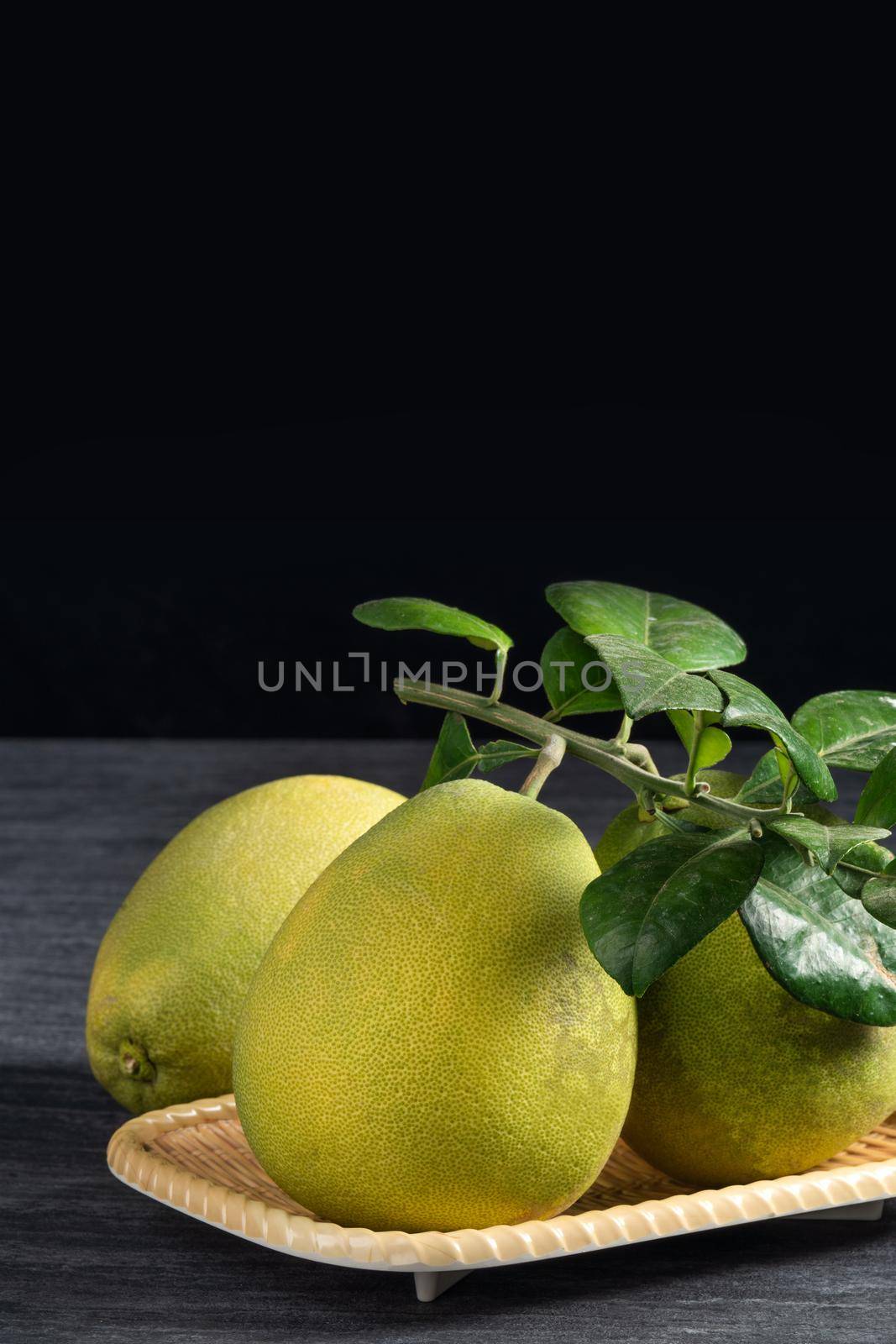 Fresh pomelo fruit on black slate background. by ROMIXIMAGE