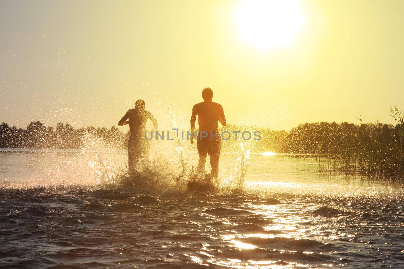 Group of young people playing games on sandy beach on a summer day.
