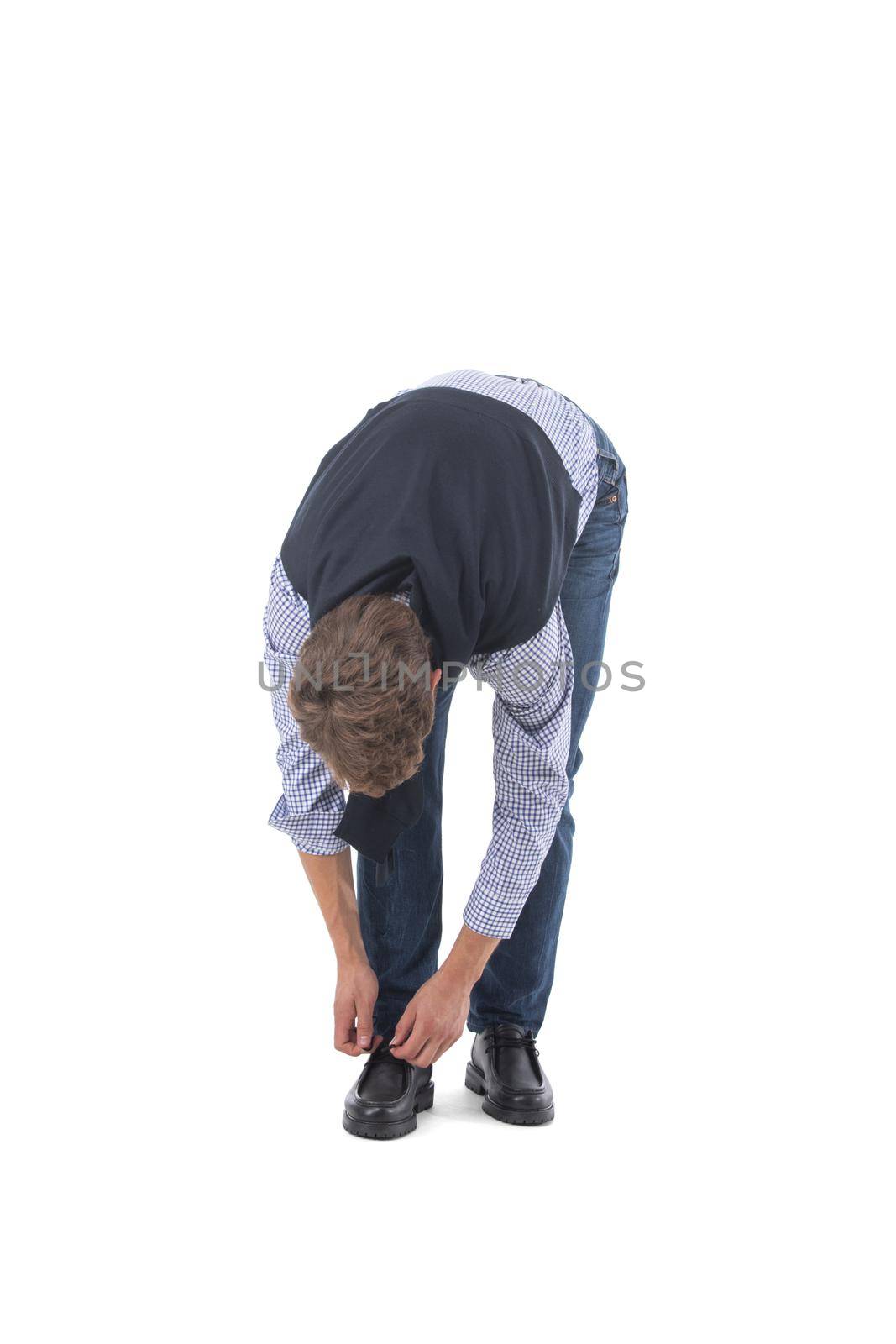 Man dressing up ties shoelaces, tying the laces, studio isolated on white background full length