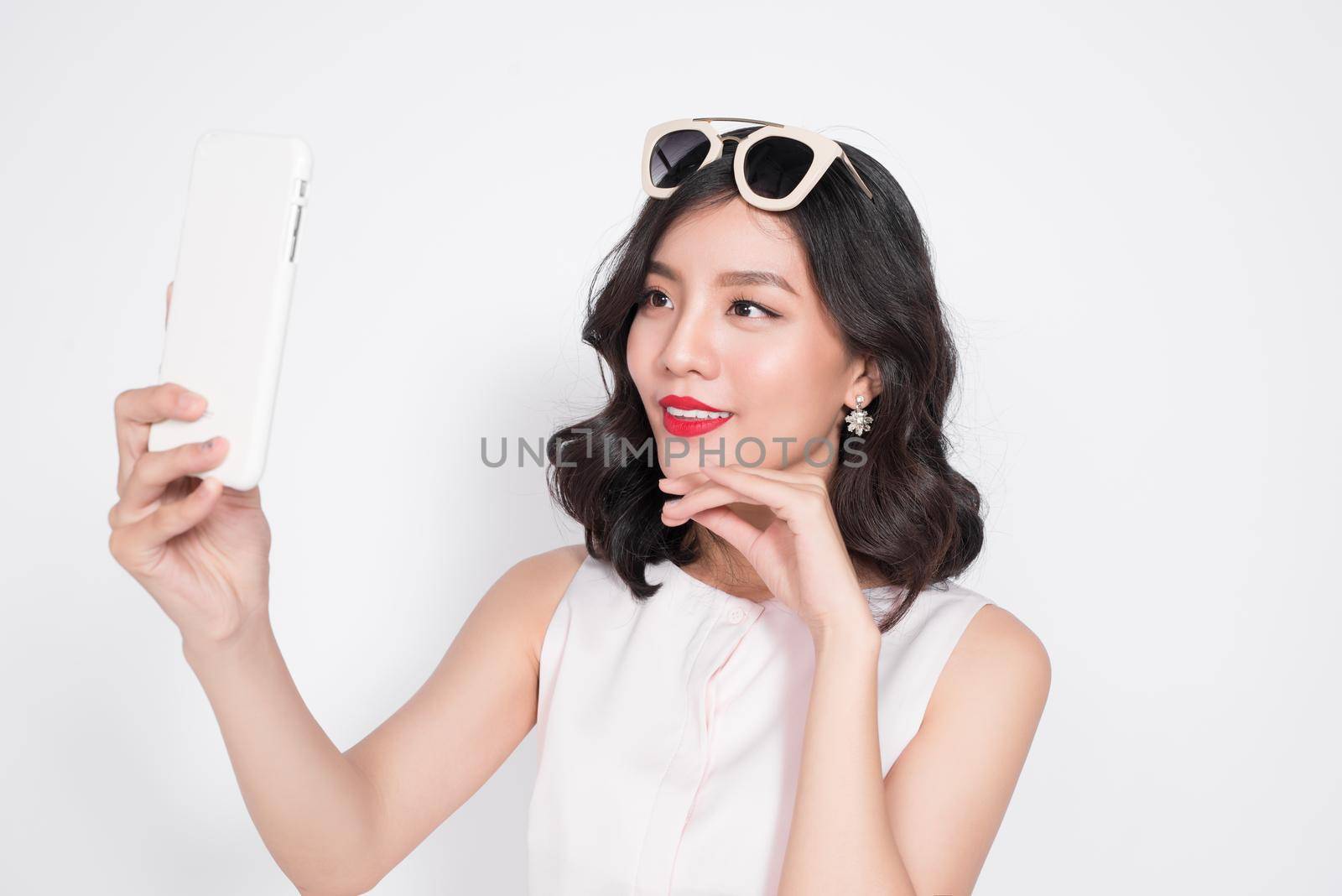 Portrait of beautiful asian fashionable girl taking selfie by makidotvn