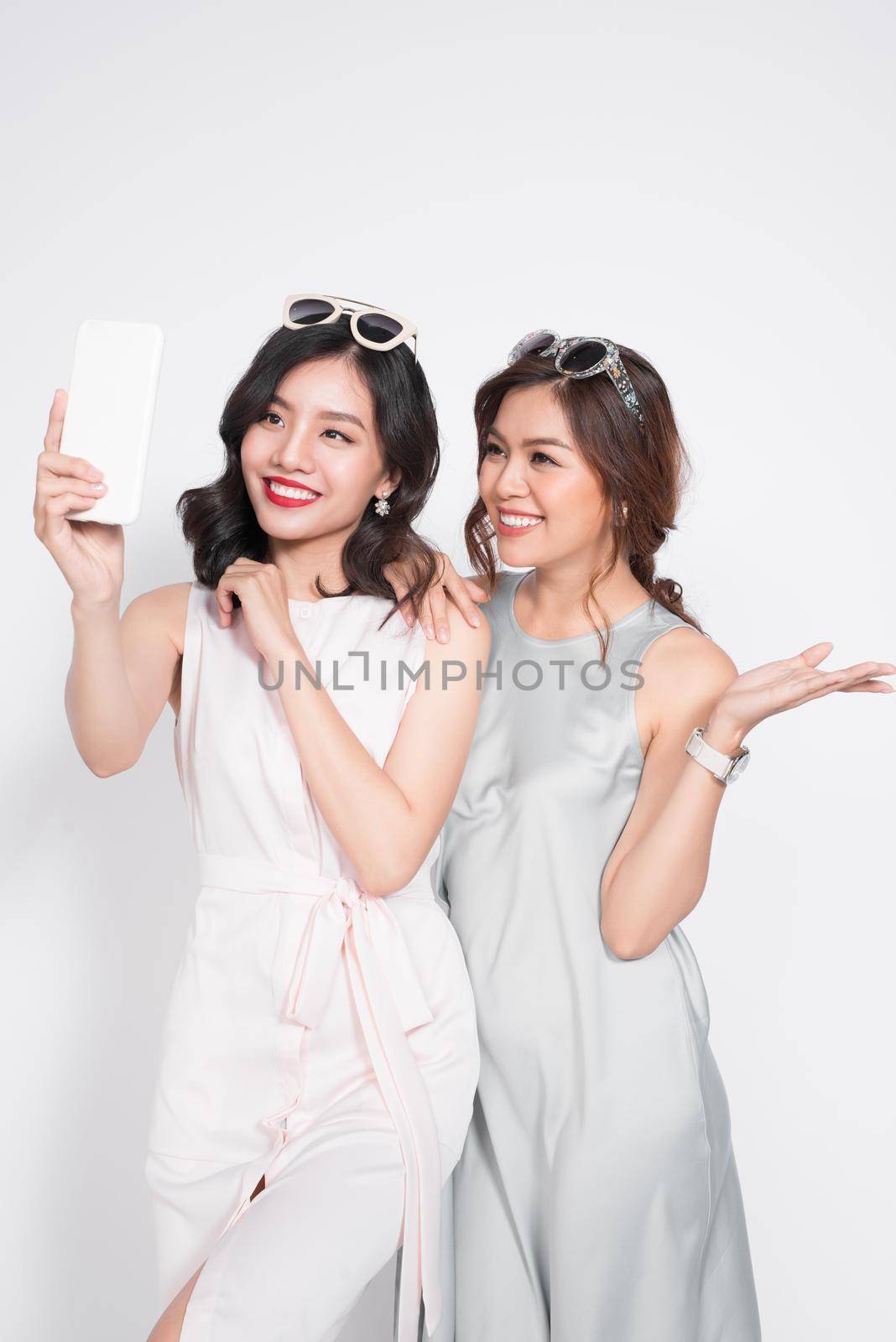 Two happy sister girls making selfie with casual style, pastel colors