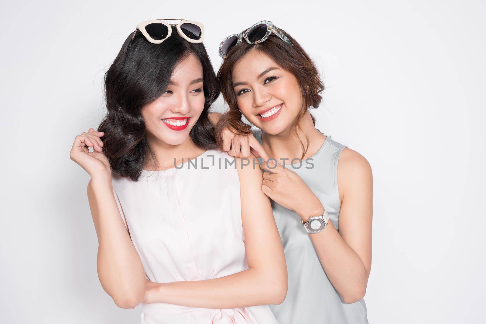 Image of a happy young two girls friends posing isolated over white wall dressed by makidotvn