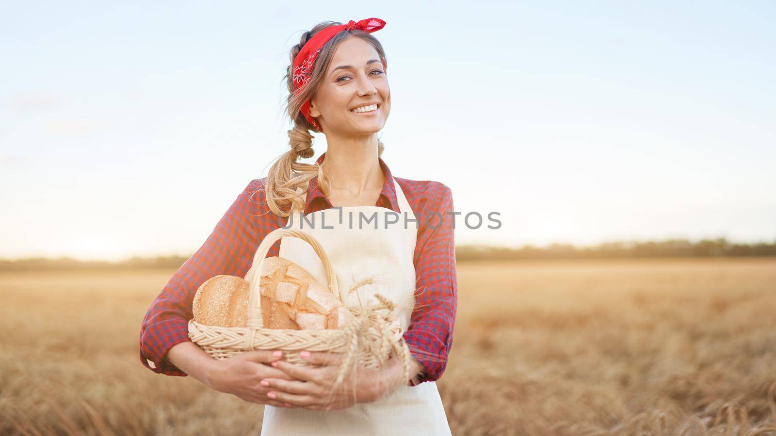 Female farmer standing wheat agricultural field Woman baker holding wicker basket bread eco product Baking small business Caucasian person dressed red checkered shirt apron organic healthy food