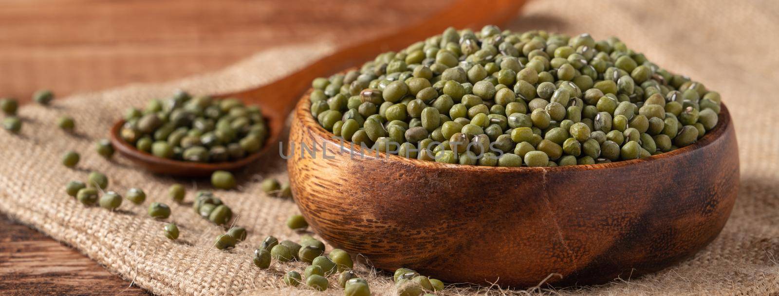Close up of raw mung bean in a bowl on wooden table background.