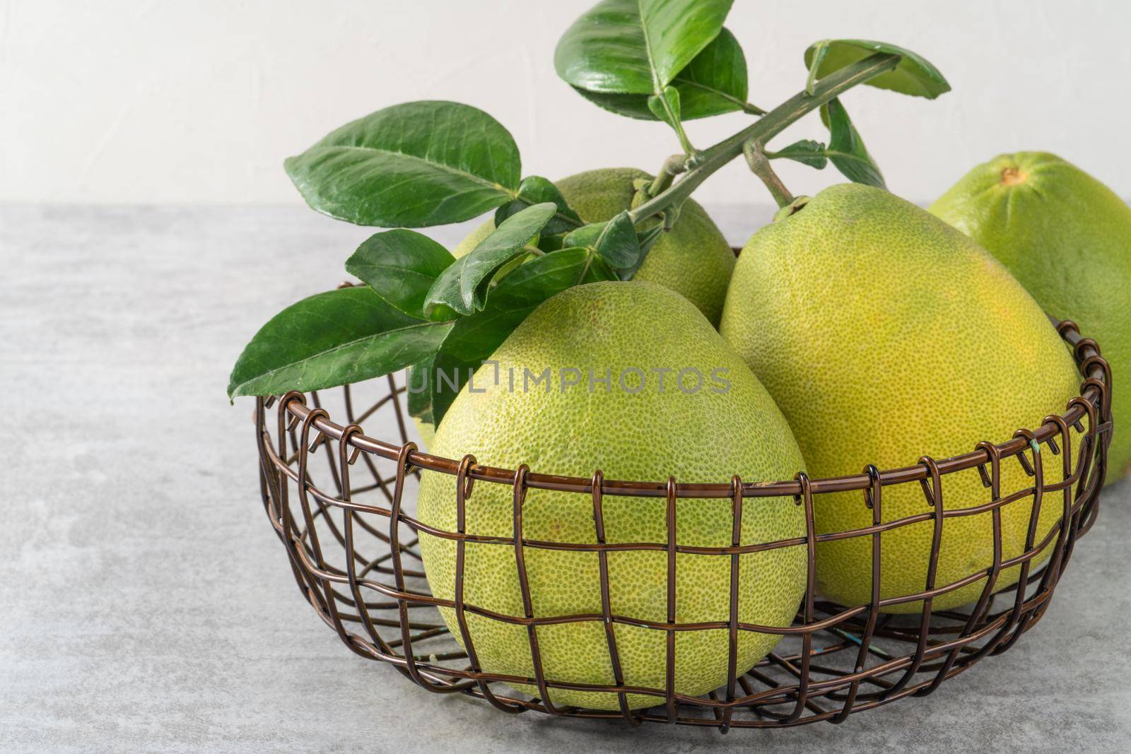 Fresh pomelo fruit on gray cement background. by ROMIXIMAGE