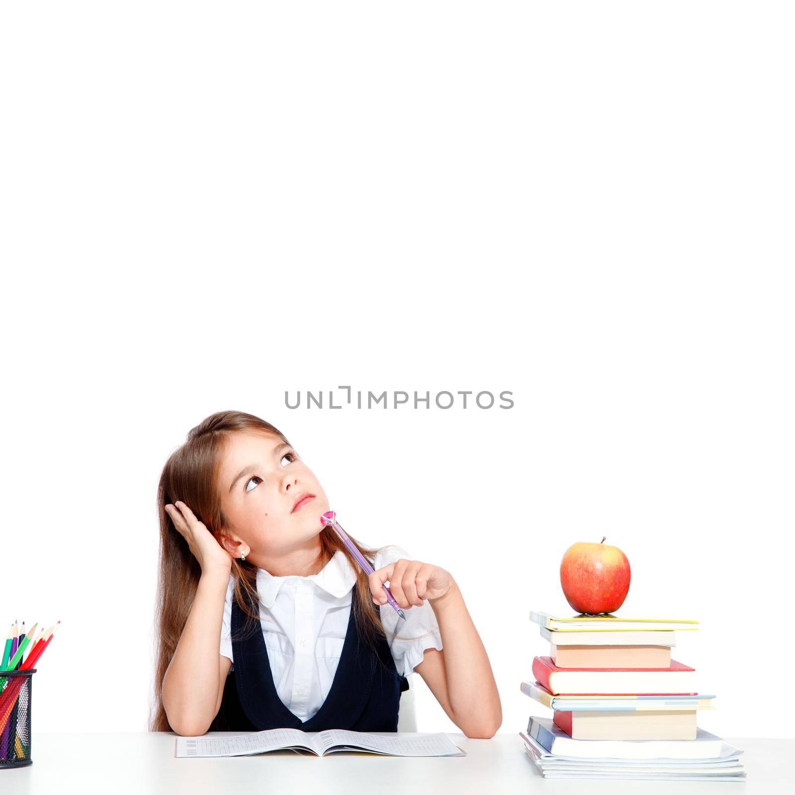 Cute little child girl looking up on the desk at school. by Taut