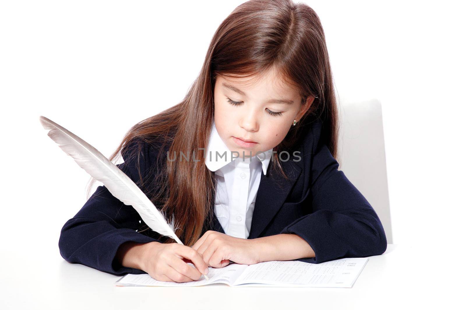 Happy and cute teen school girl writes in a book or notebook by Taut