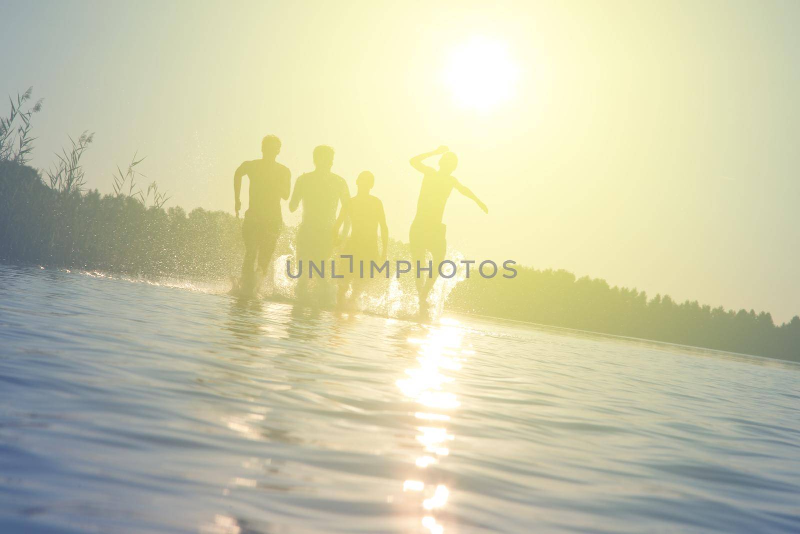 Group of young people playing games on sandy beach on a summer day.