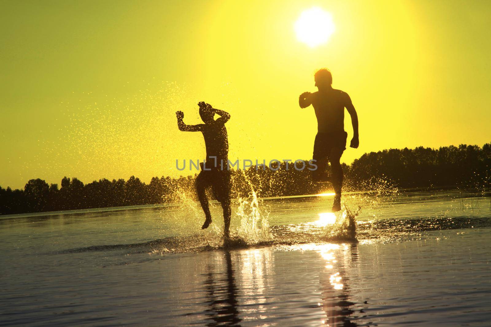 Group of young people playing games on sandy beach on a summer day.