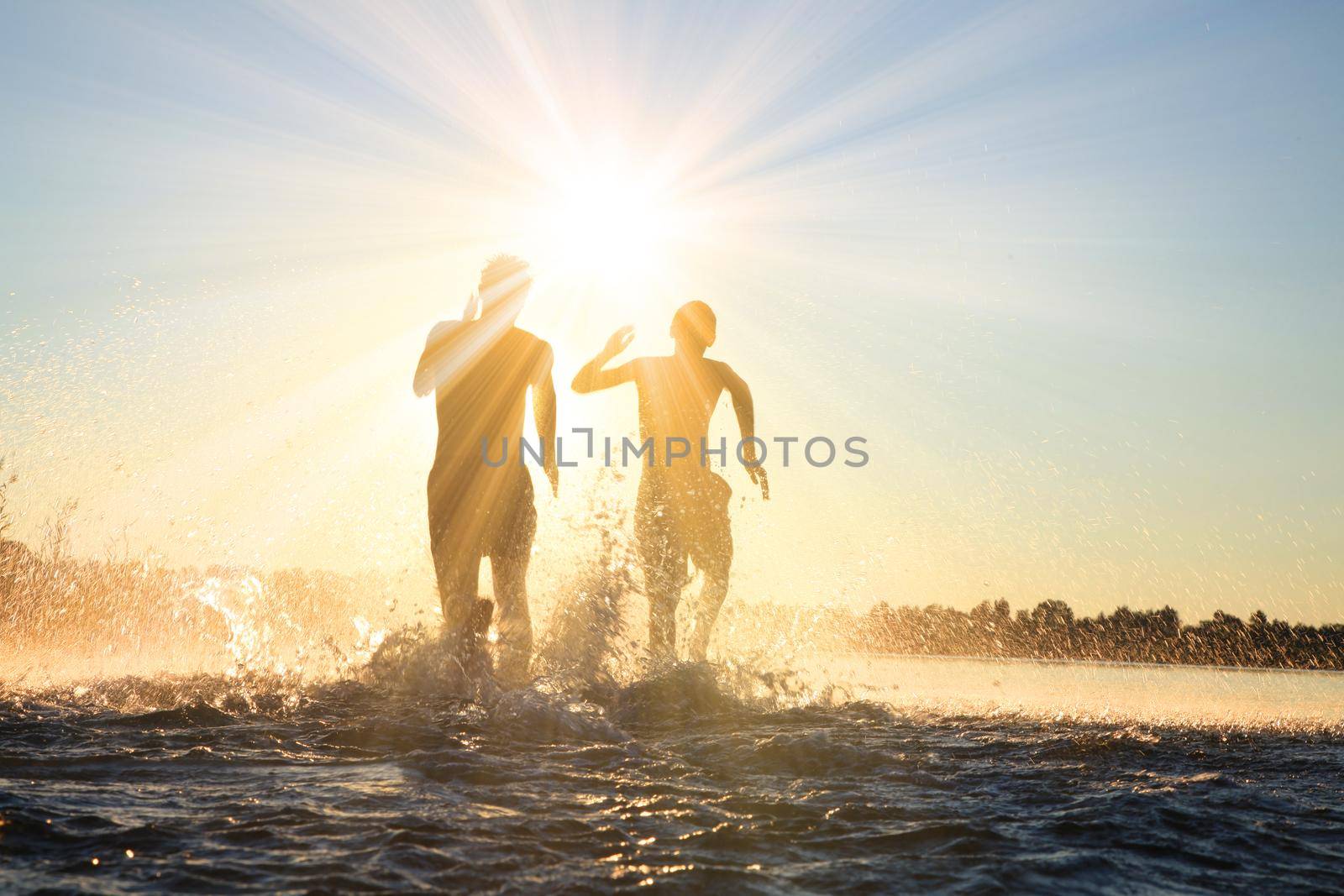 Group of young people playing games on sandy beach on a summer day.