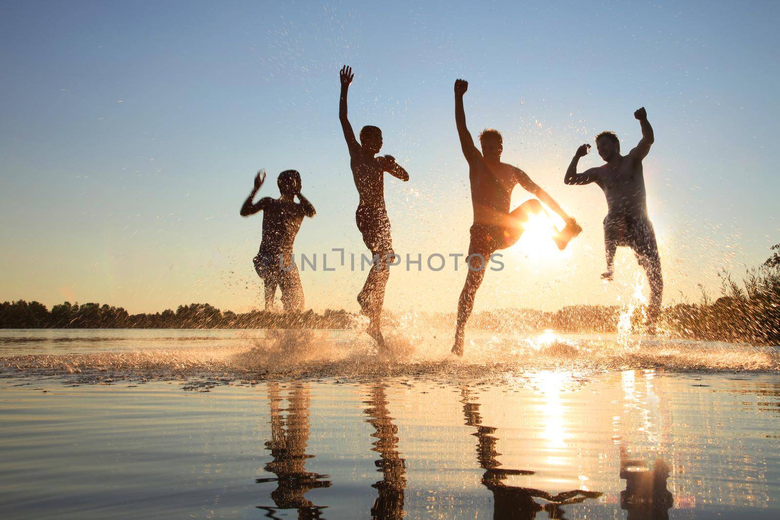 Group of young people playing games on sandy beach on a summer day.