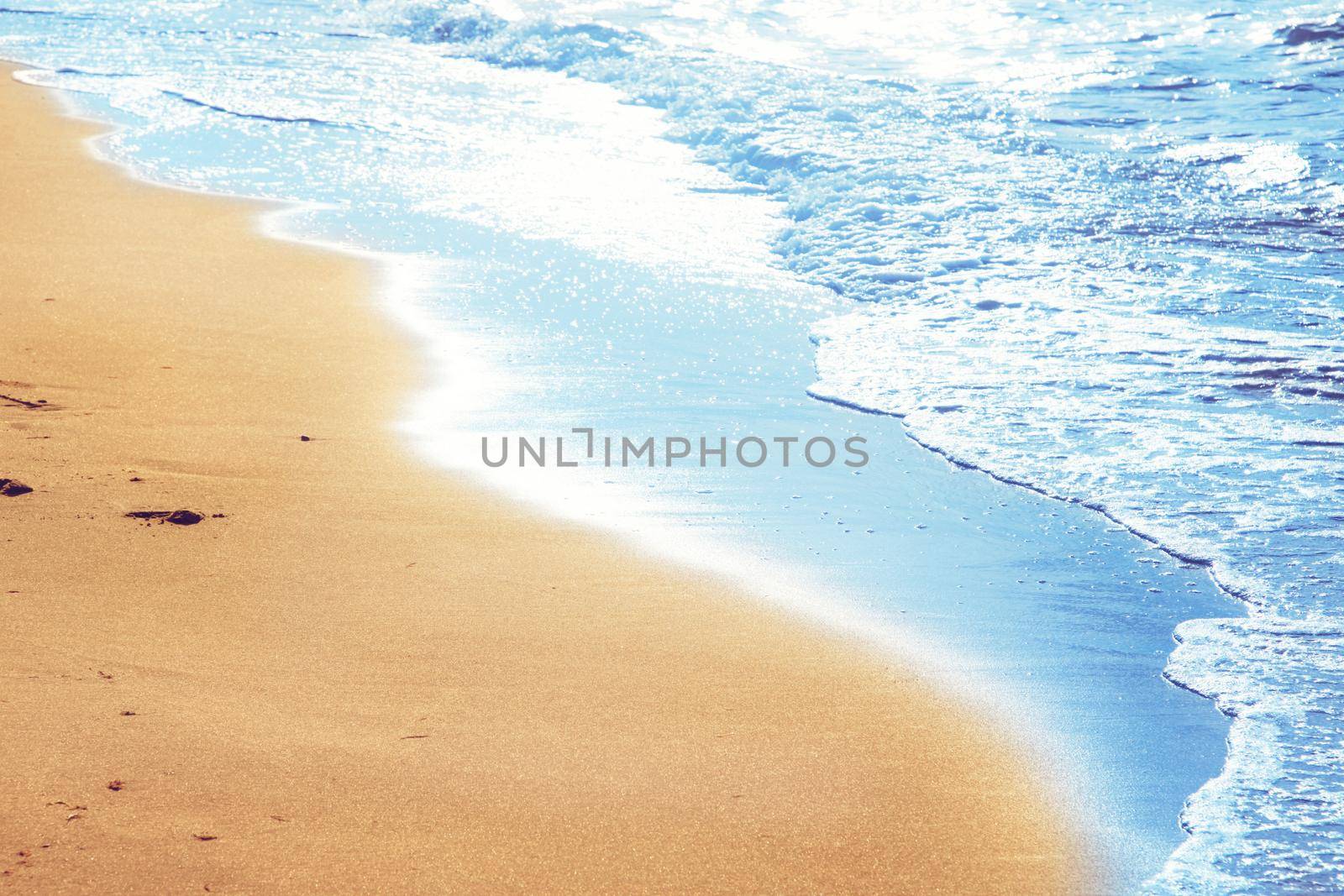 Detail of human feet in the golden sand at the beach. Summer travel and vacation concept.