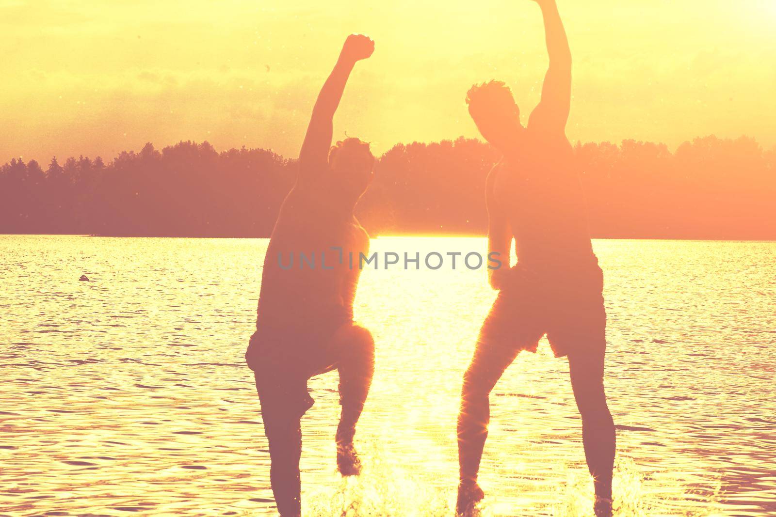 Group of young people playing games on sandy beach on a summer day.