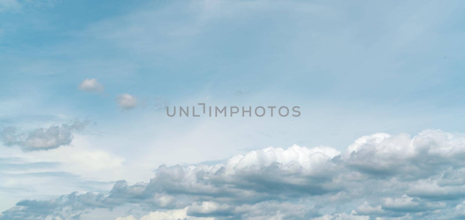 Panorama view of white fluffy clouds on blue sky. Close-up white cumulus clouds texture background. White puffy cloudscape. Beauty in nature. Soft-touch feeling like cotton. Beautiful cloudscape.