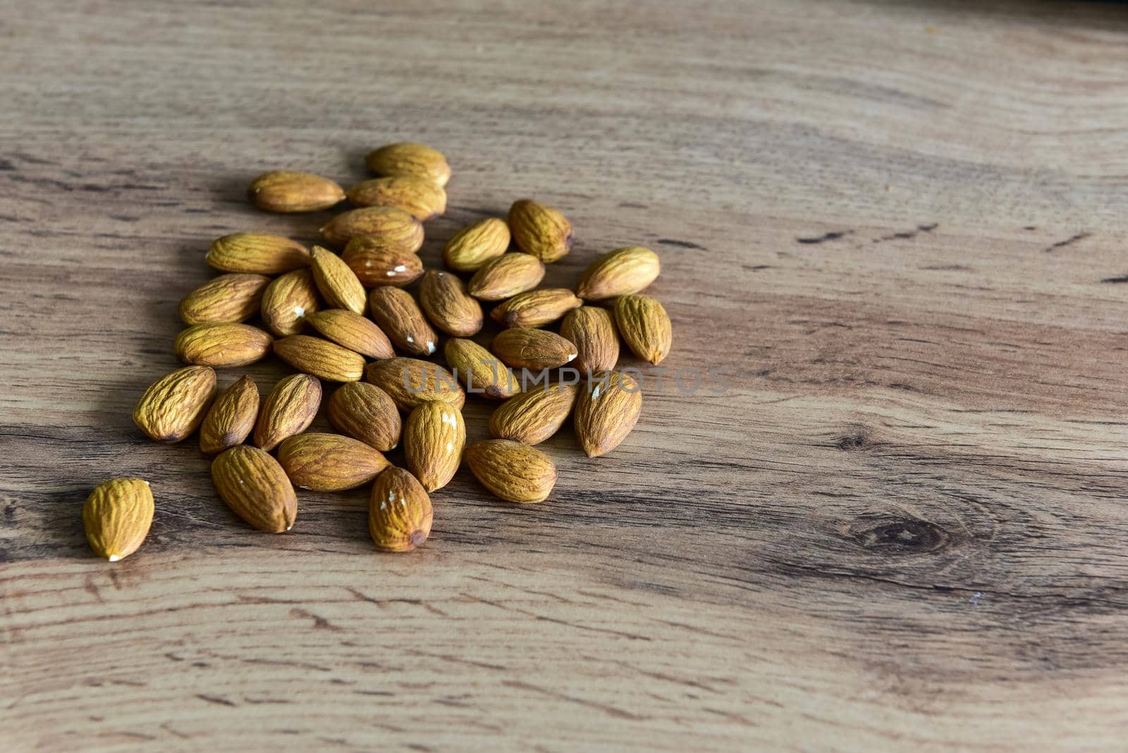 Almonds lying on the table by the handful.