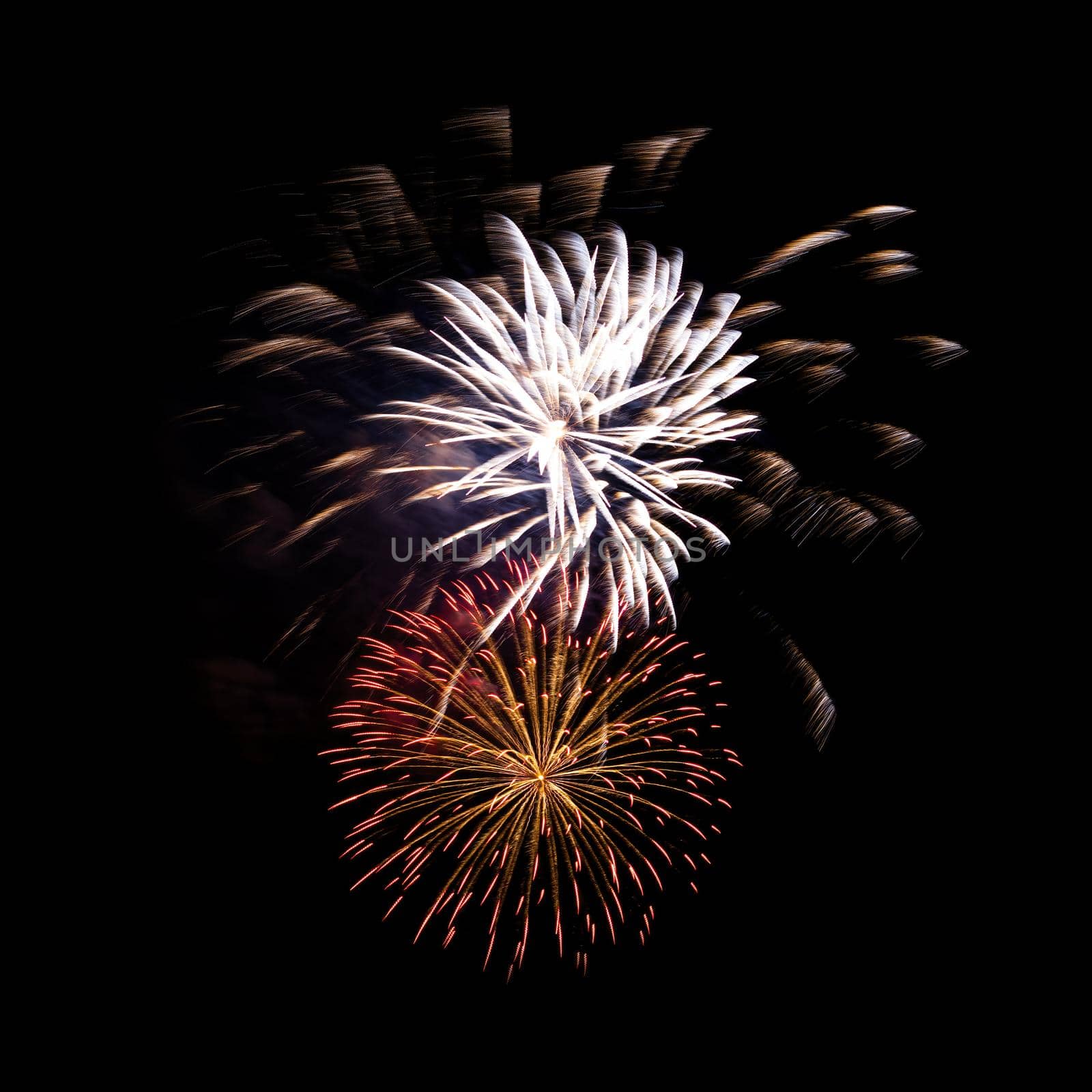 Colorful celebration fireworks isolated on a black sky background.