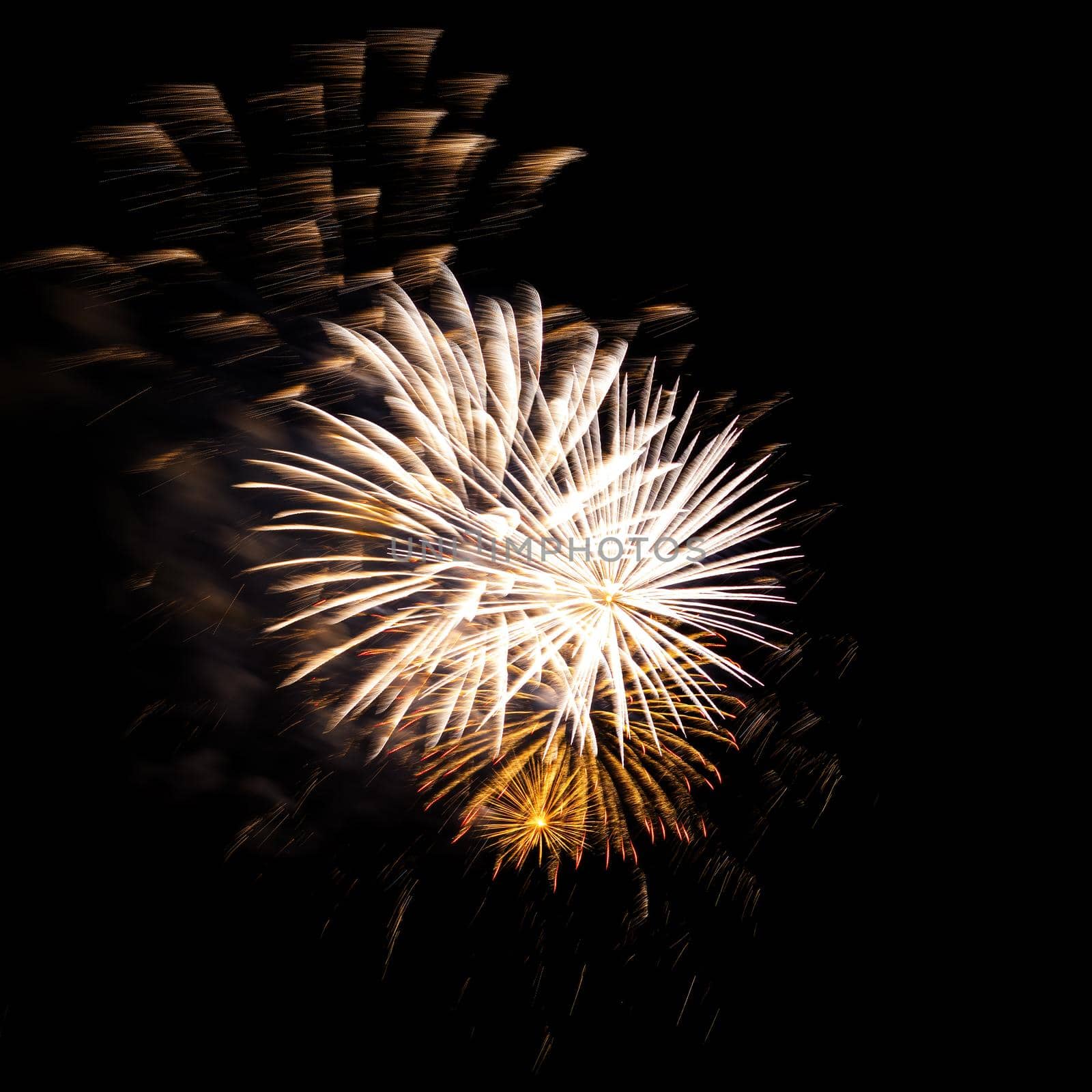 Colorful celebration fireworks isolated on a black sky background.